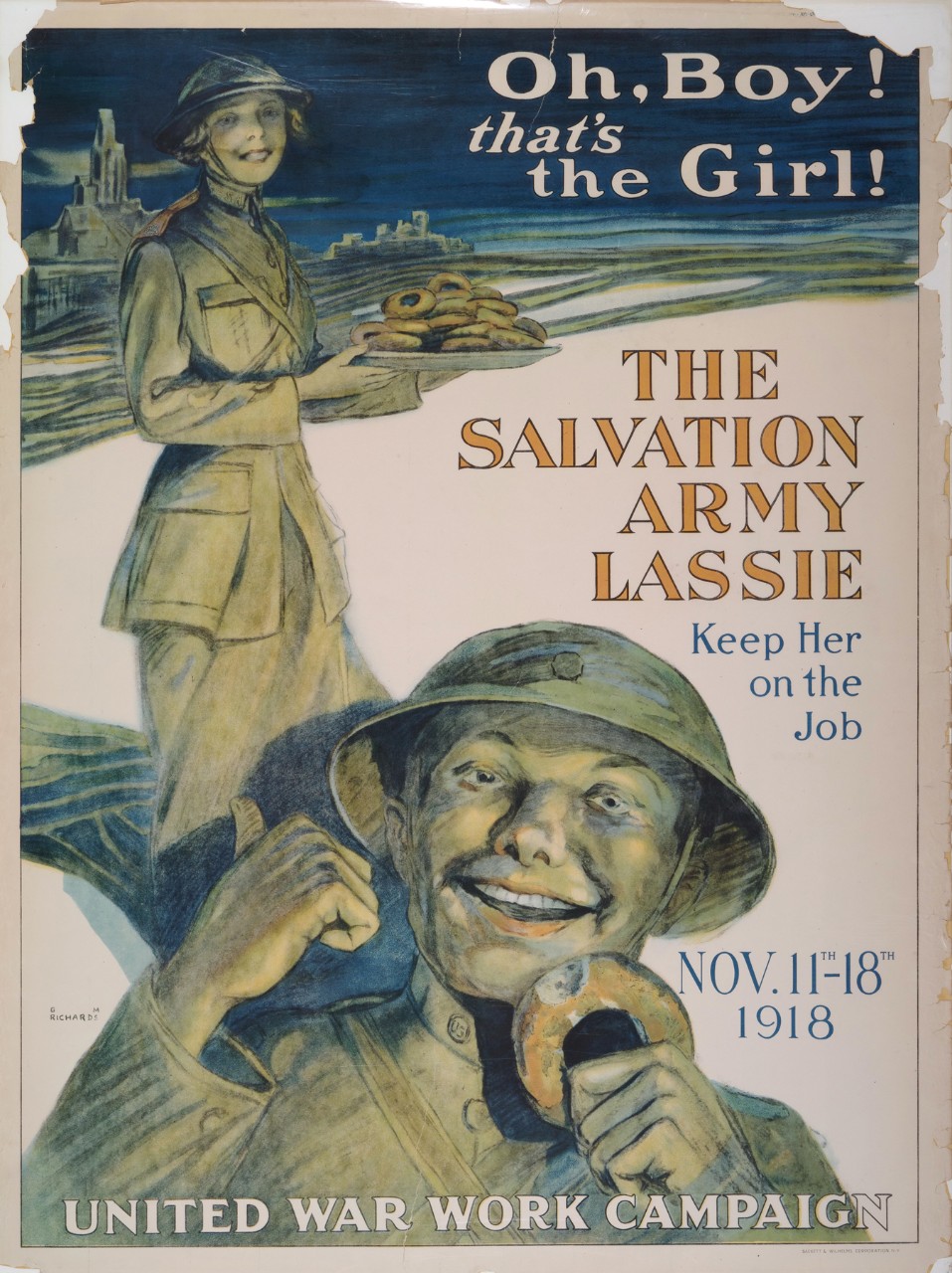 A soldier is eating a doughnut while a woman in uniform holding a plate of doughnuts stands behind him  