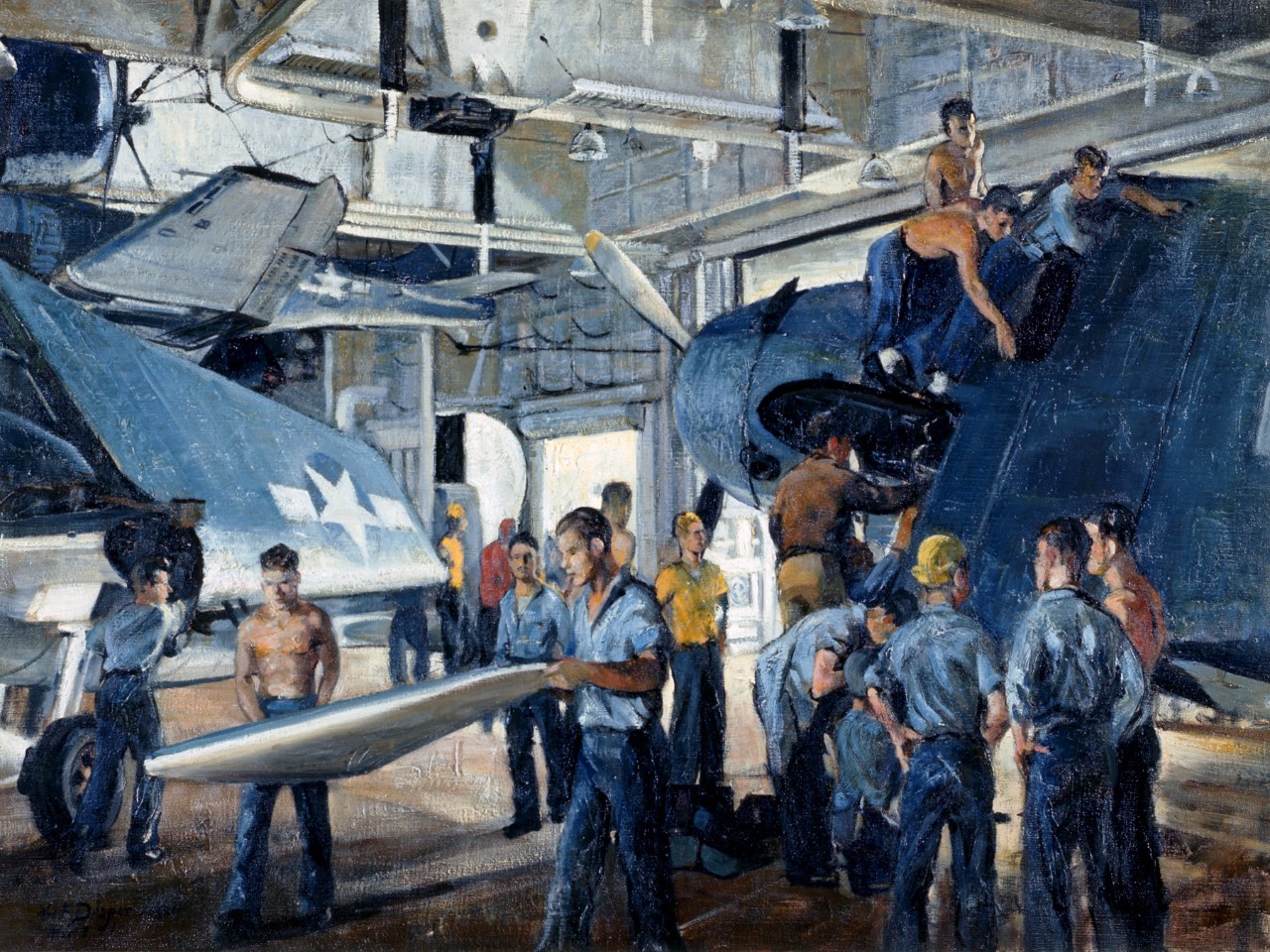 Sailors work on aircraft in the hanger of an aircraft carrier