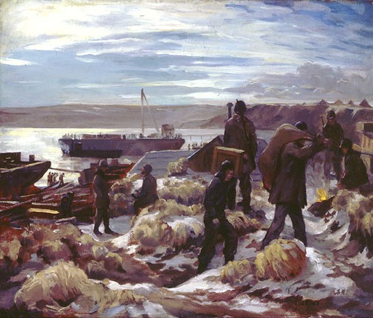 Men carrying supplies from the landing craft on the beach up a hill