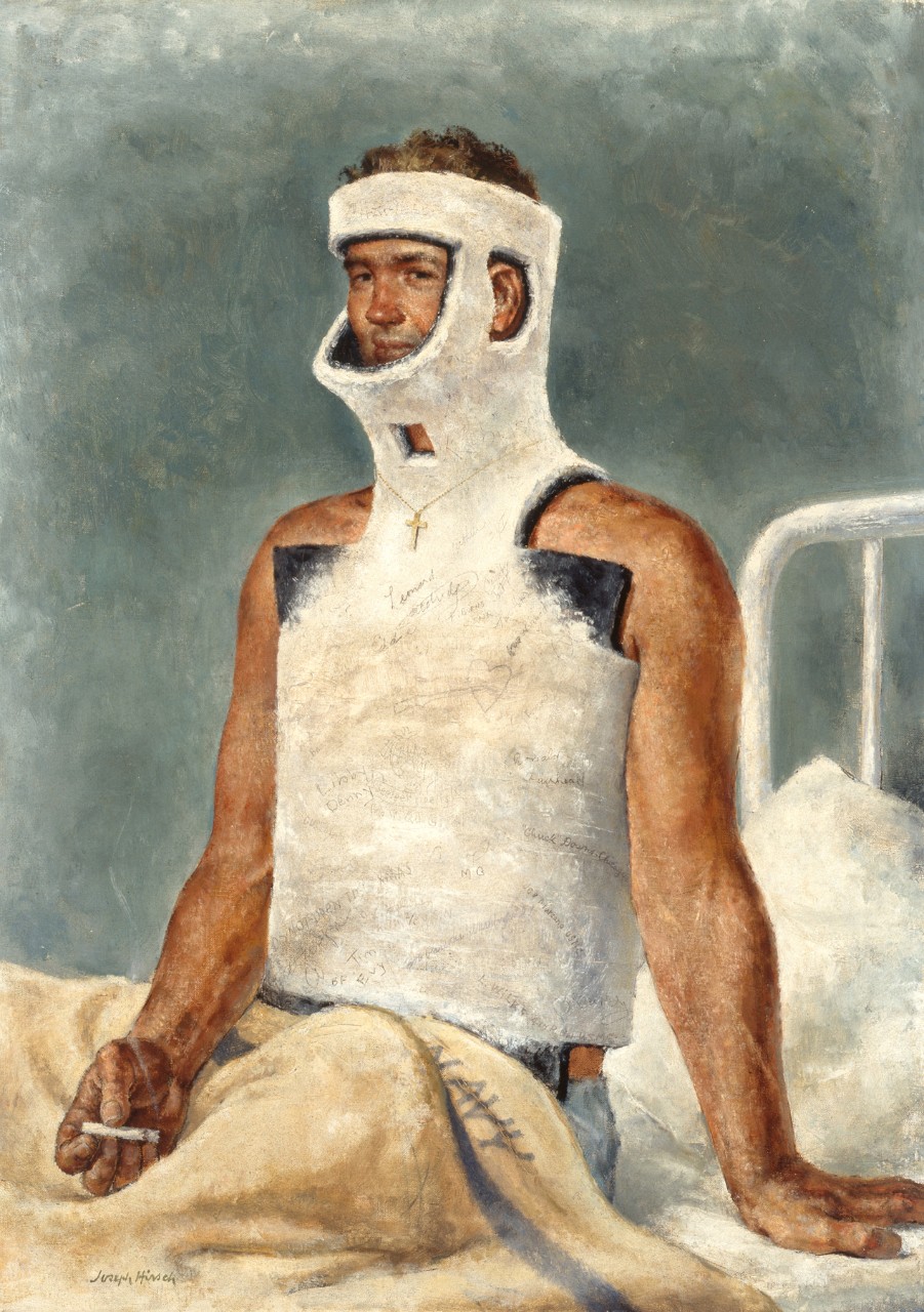 A man in a body cast is sitting on a bed smoking a cigarette