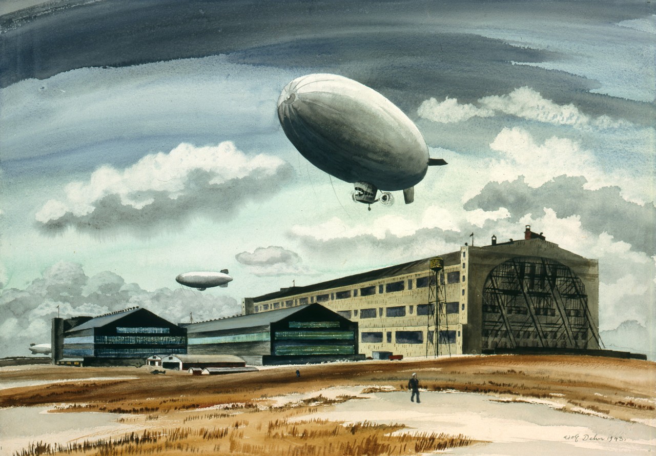 A blimp flies over an airfield