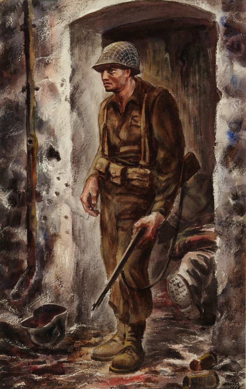 Soldier stands in front of a ruined house