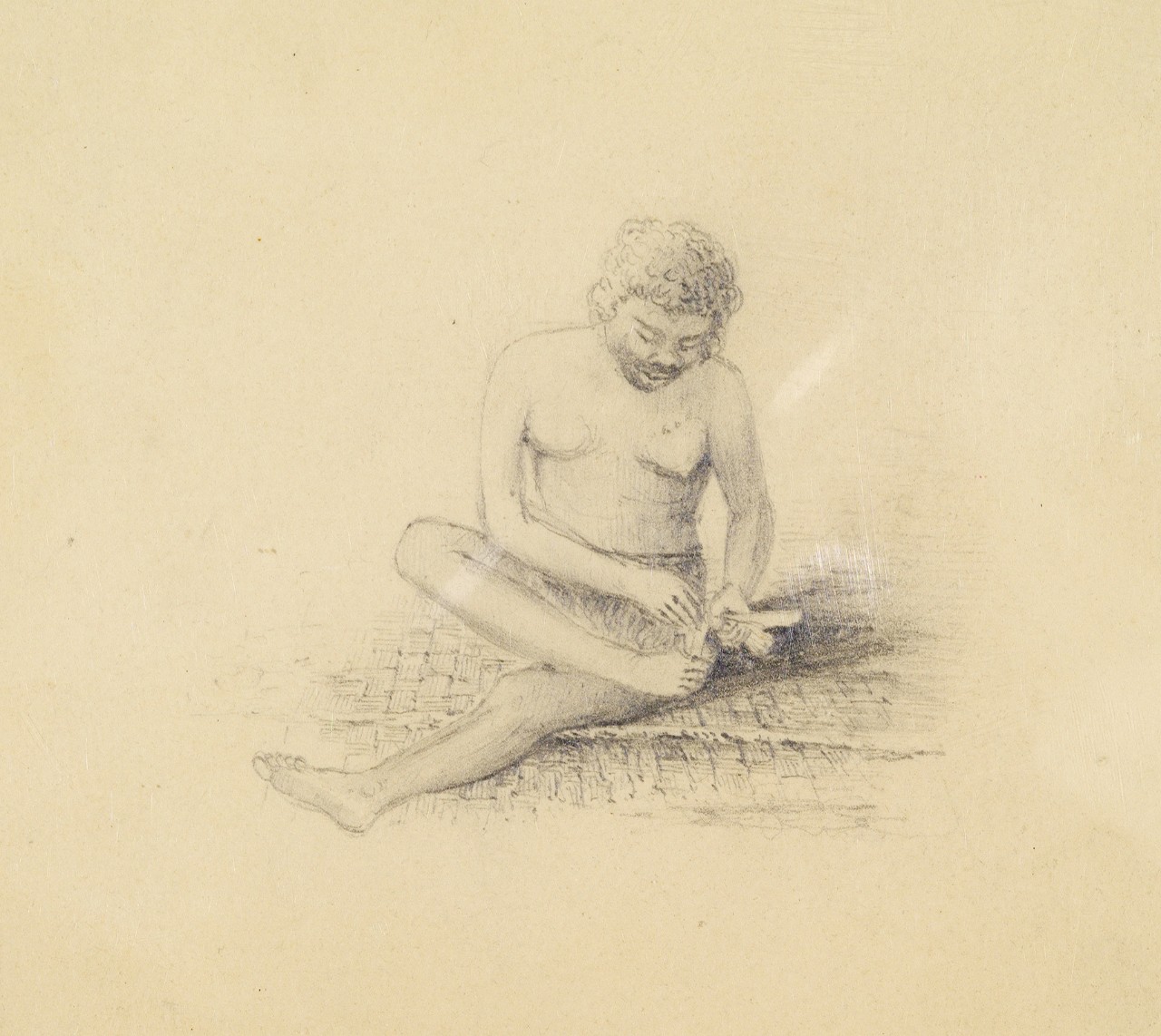A woman seated on the ground working 