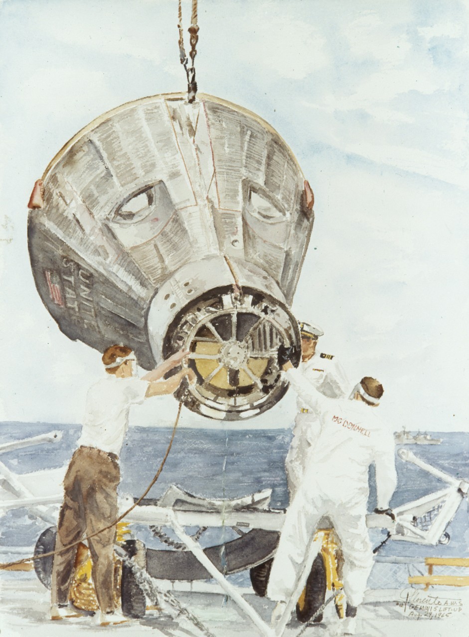 Two men guide the module as it is being lifted by a crane onto the deck of a ship