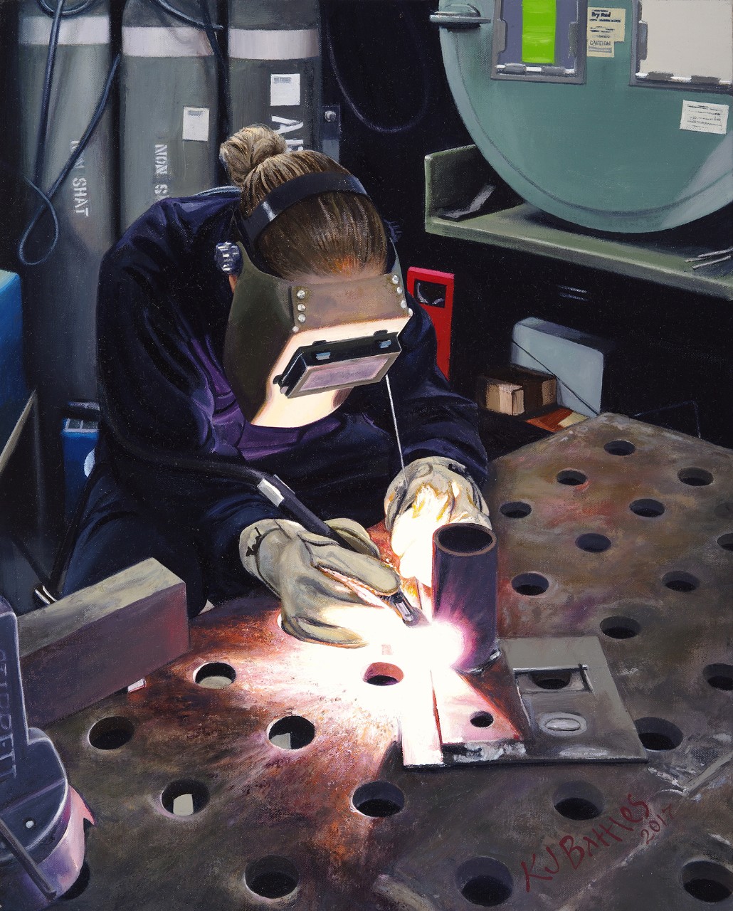A Woman in a welder’s mask is working on a piece of pipe