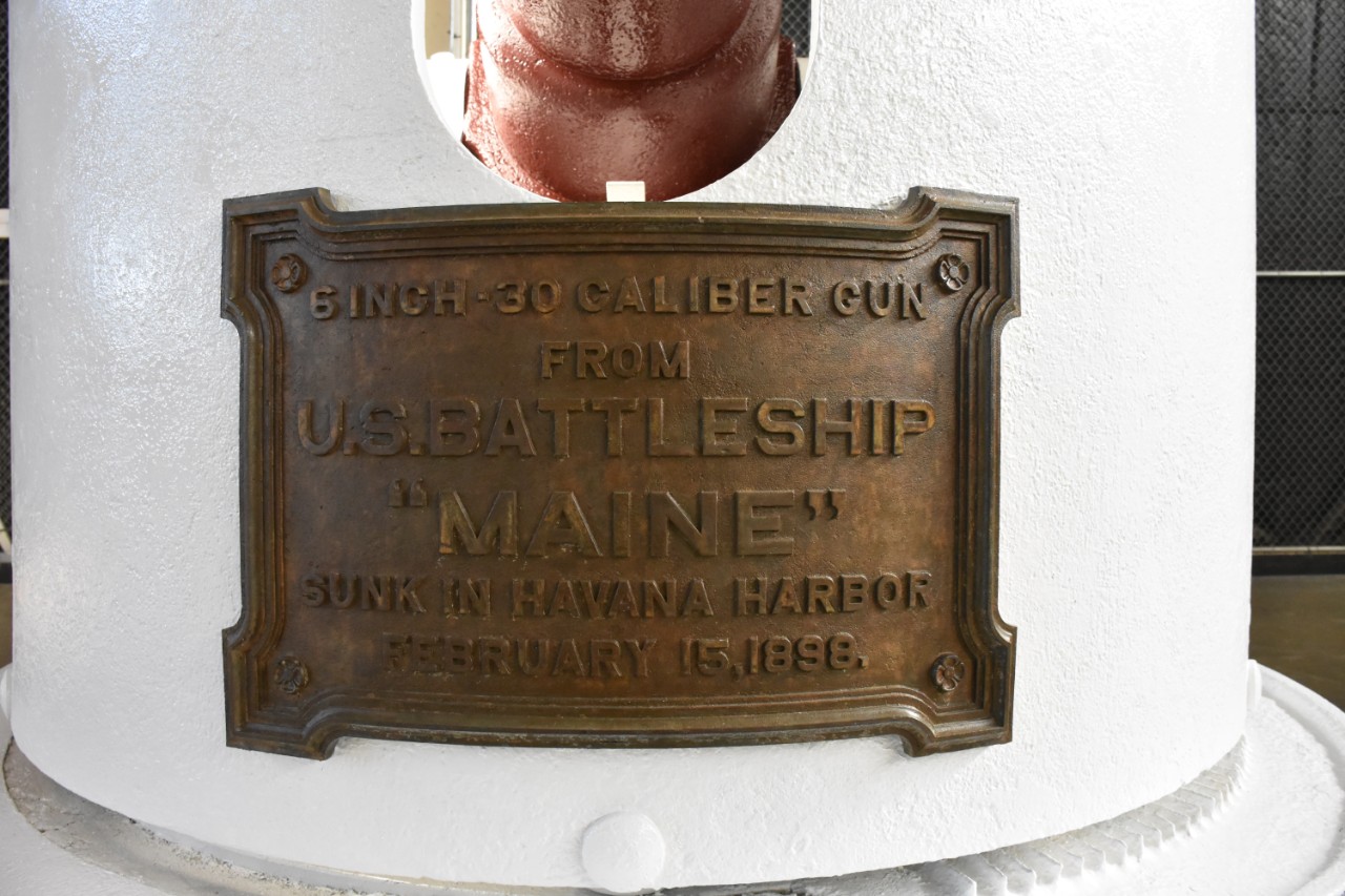 Bronze plaque affixed to front of gun shield. "6-Inch 30 Caliber Gun From US Battleship 'Maine' Sunk in Havana Harbor February 15 1898"
