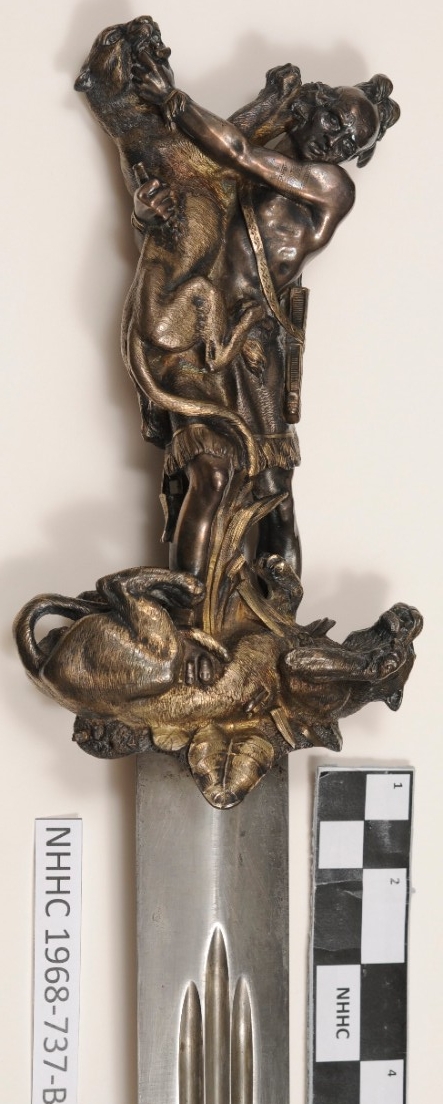 Stylized sword hilt in figure of an American Indian in combat with two panthers.  