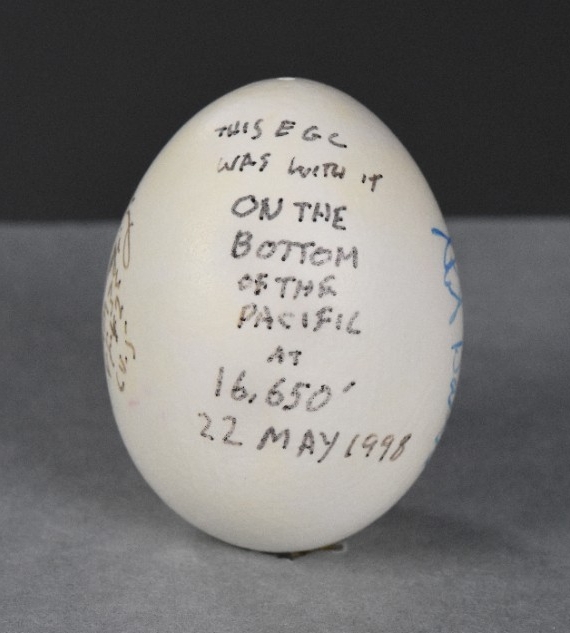 One egg, emptied of its contents, painted and signed. The reverse of the egg is marked “This egg was with it on the bottom of the Pacific at 16,650’ 22 May 1998.” 