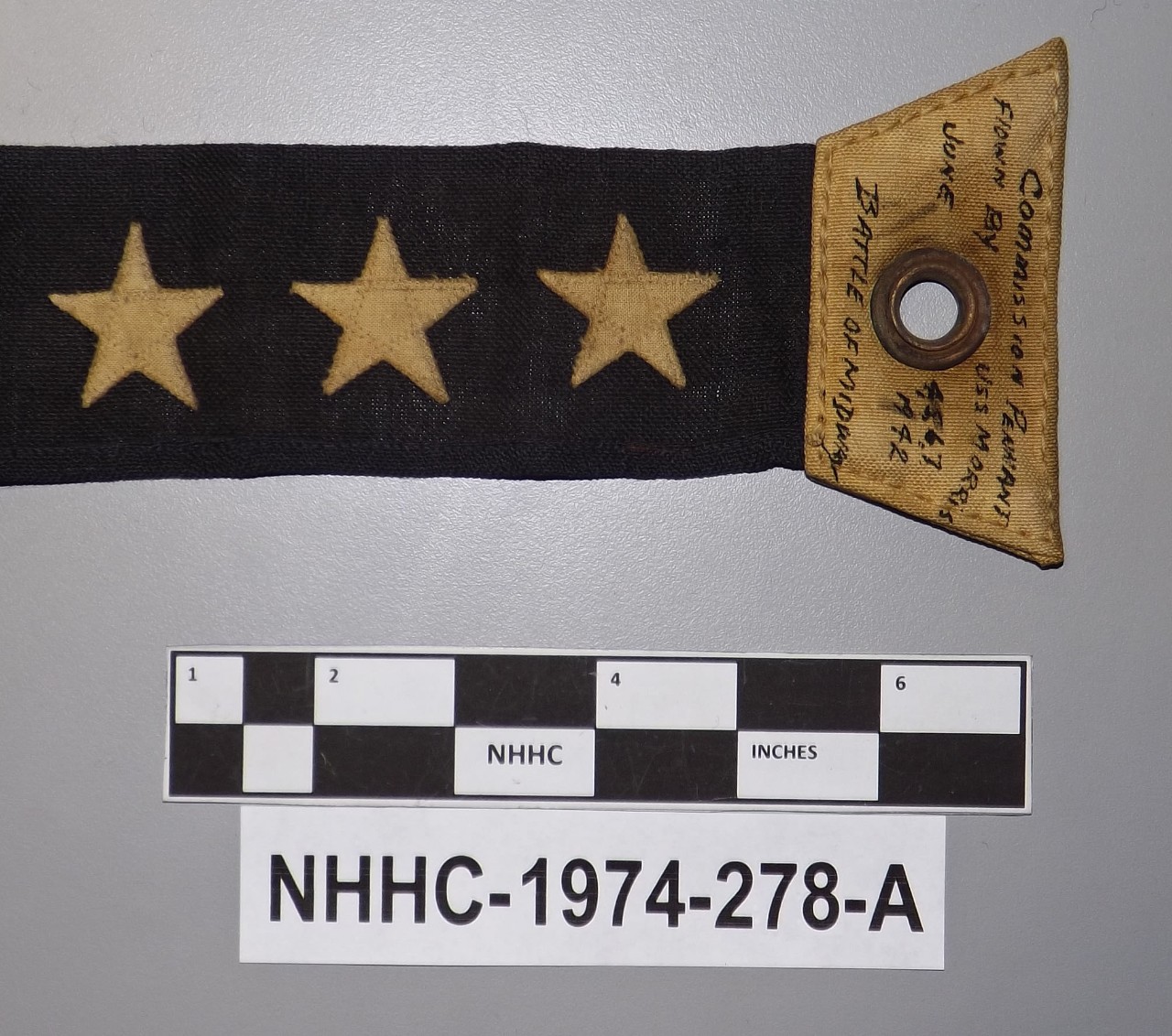 One US Navy commissioning pennant from USS Morris (DD-417). Black ink lettering on the hoist reads "Commission Pennant / flown by USS Morris / June 4, 5, 6, 7, / 1942 / Battle of Midway".