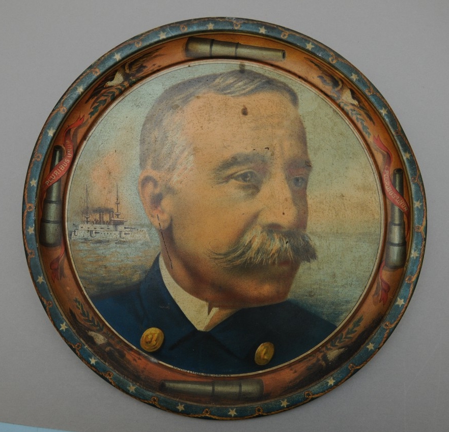 Tin Plate Bust of George Dewey with ships in the background Rim is Navy Guns in a ciricle