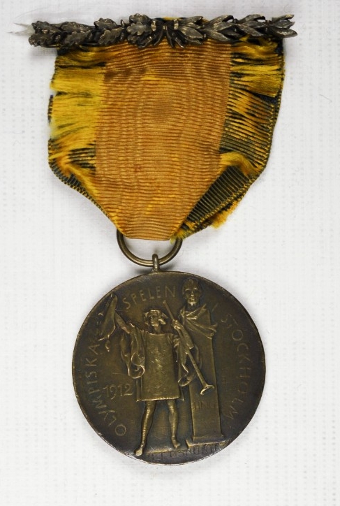 Obverse view of 1912 Olympic Bronze medal of Carl T Osburn yellow and blue ribbon round planchette and pin and clasp bar