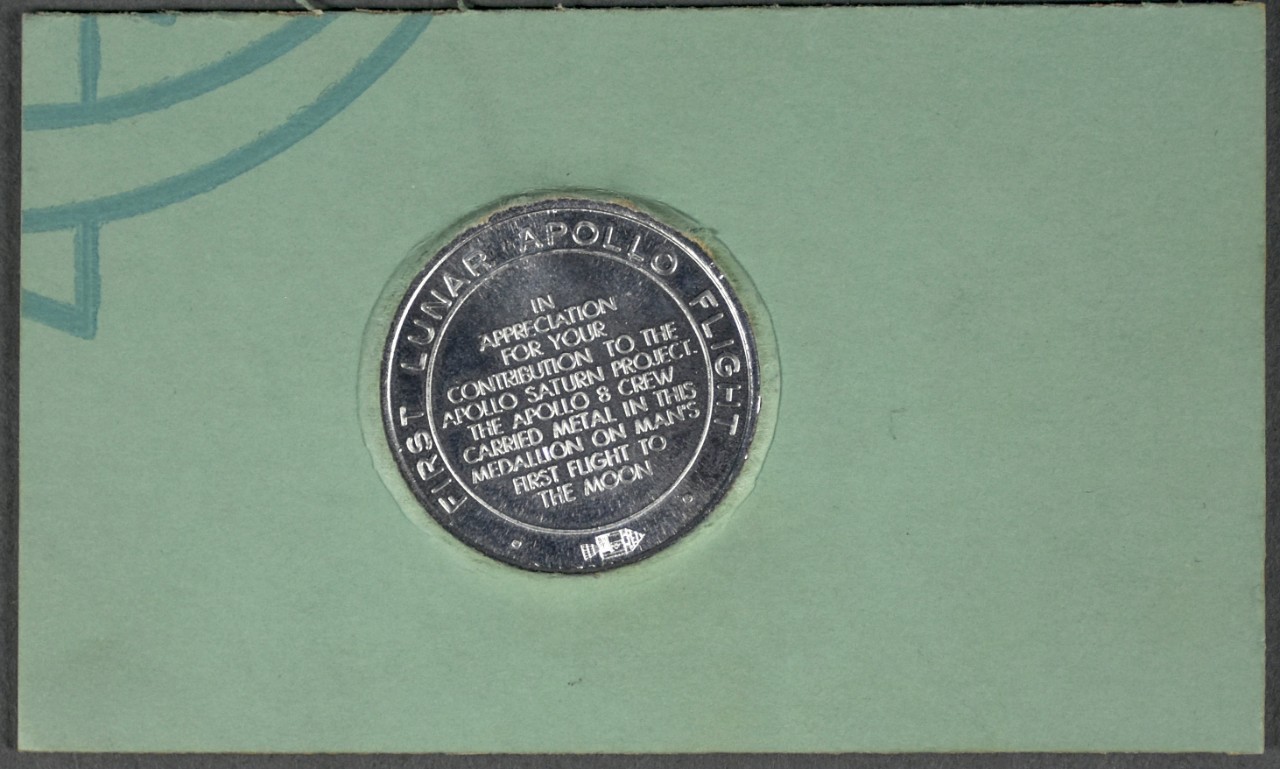 cardboard stamped card with reverse of coin visible from apollo 8 recovery