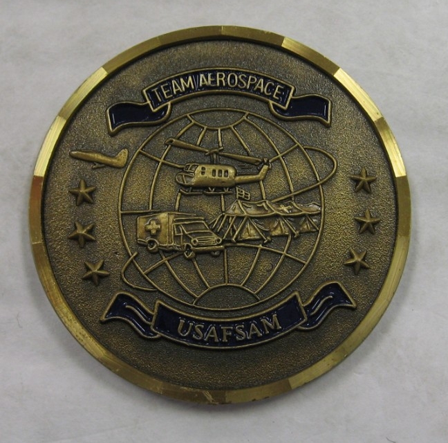 This commemorative Medallion from the United States Air Force School of Aerospace Medicine is a circular medallion with the inscription "Team Aerospace / USAFSAM" with a globe with grid lines and a helicopter, field hospital tents, and ambulance ...