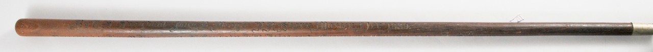 Wooden cane with Old English script along all sides of the cane