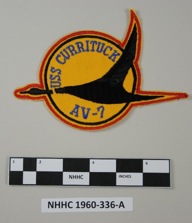 Shoulder patch with a black duck at the center a red border and yellow field and blue lettering
