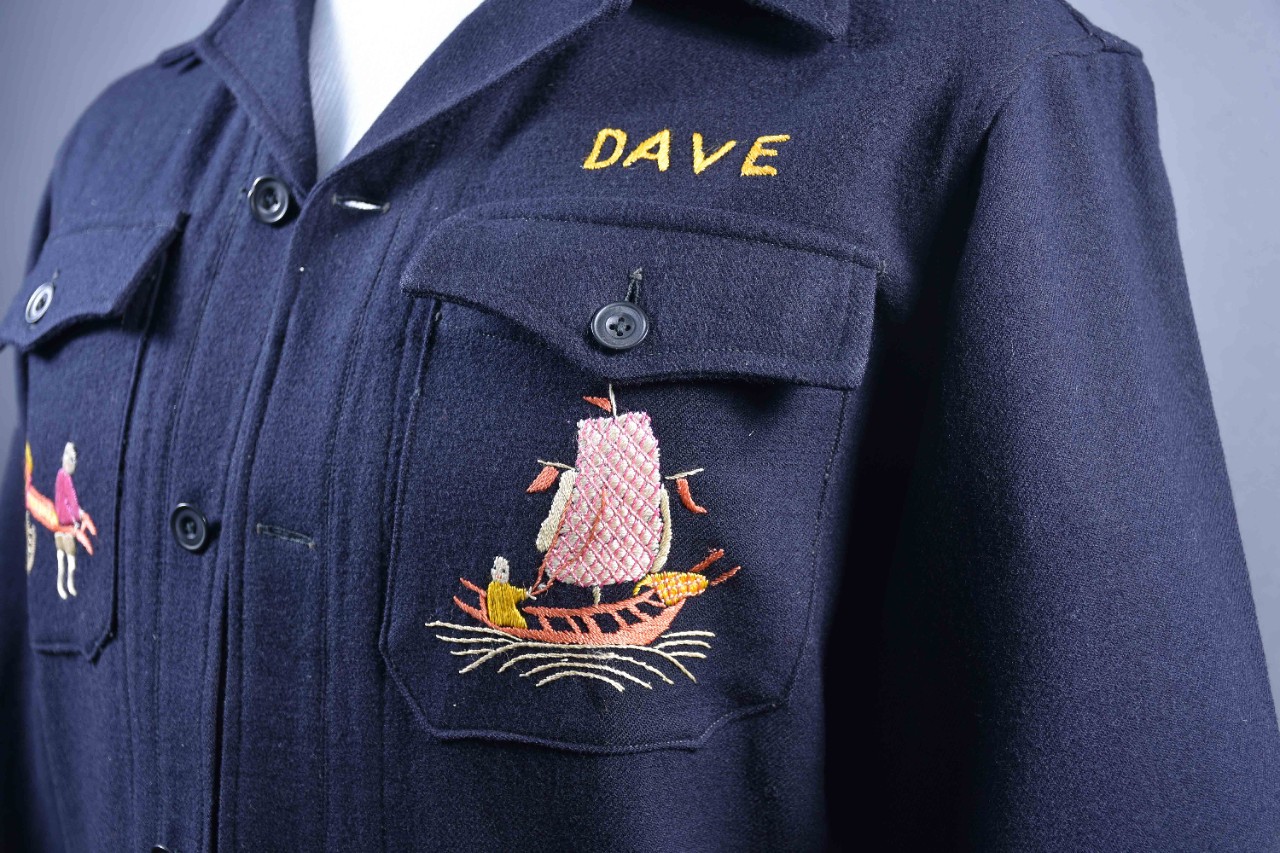 Close-up of the front left breast pocket with a colorfully embroidered Chinese junk and the name Dave embroidered in yellow above the pocket.