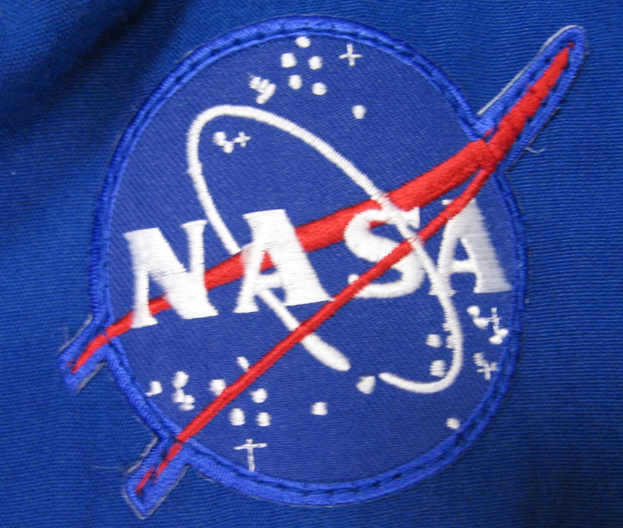 NASA patch on right chest of NASA coveralls.