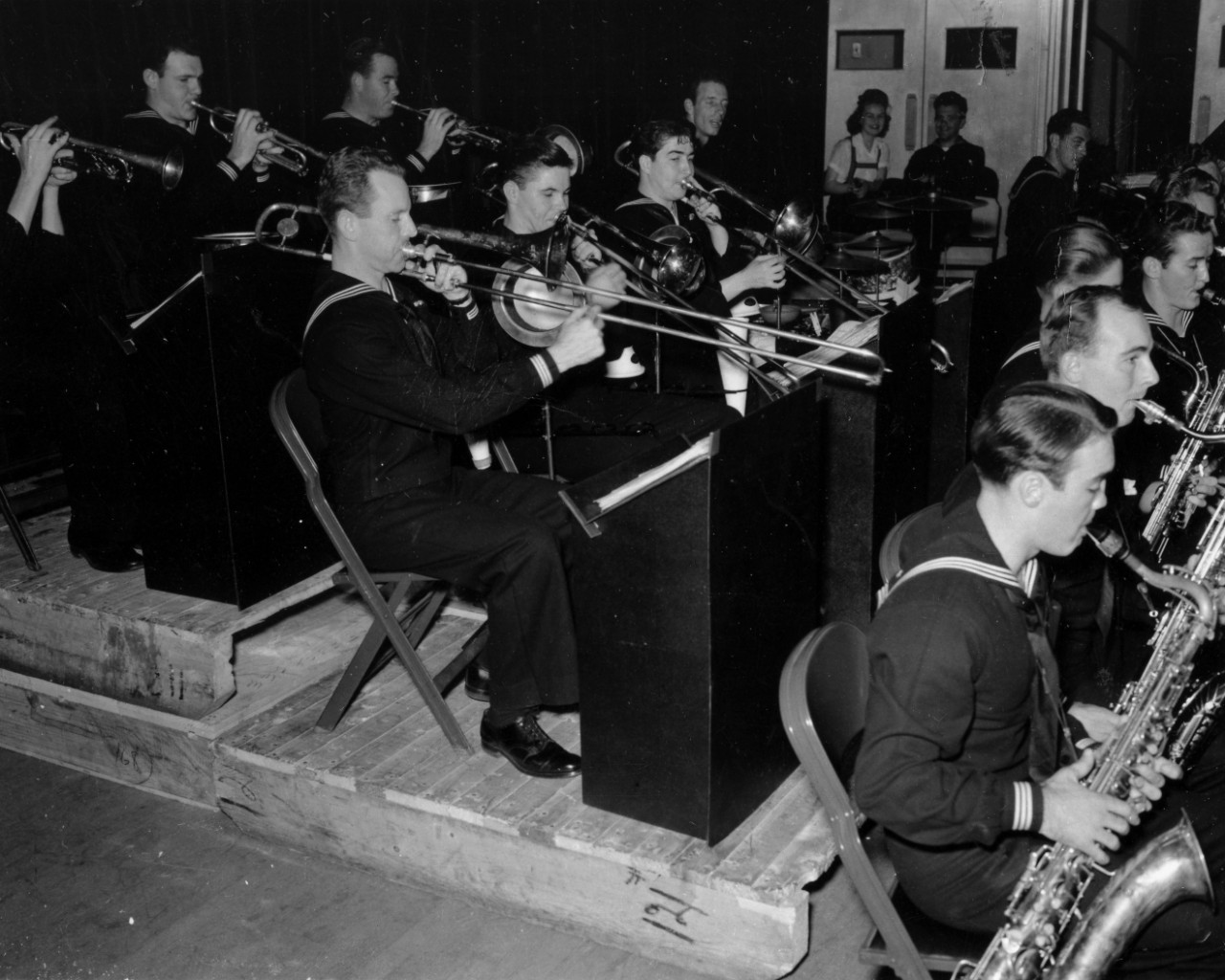 Collection of 18 photographs related to John C. Hedigan, a US Navy musician (trumpeter) during WWII. The images consist of Hedigan in uniform with rates up through Muscian, 1c, during the 1940s, plus some views in civilian dress and in the uniform of an unidentified band. Also included are views of the Navy Band at Portland, ME, circa 1943-1945, with Hedigan in each photograph, as well as the Navy Band playing at the Bureau of Engraving dance in Washington, DC, 1942. Part of this collection also includes an oversized panoramic image of company 42-127, Naval Training Station San Diego, listed as S-515-A, of which Hedigan was a member in 1942. 
