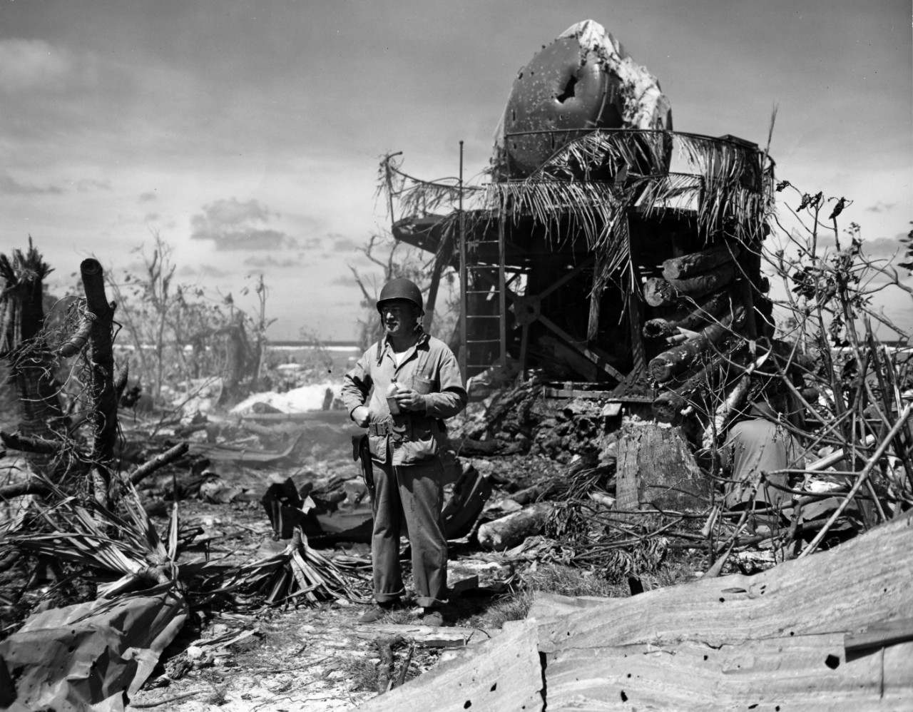 A sailor standing in front of a bombed radar tower on Kwajalein after the invasion, February 1944. From the VADM Robert C. Giffen Photo Collection. 