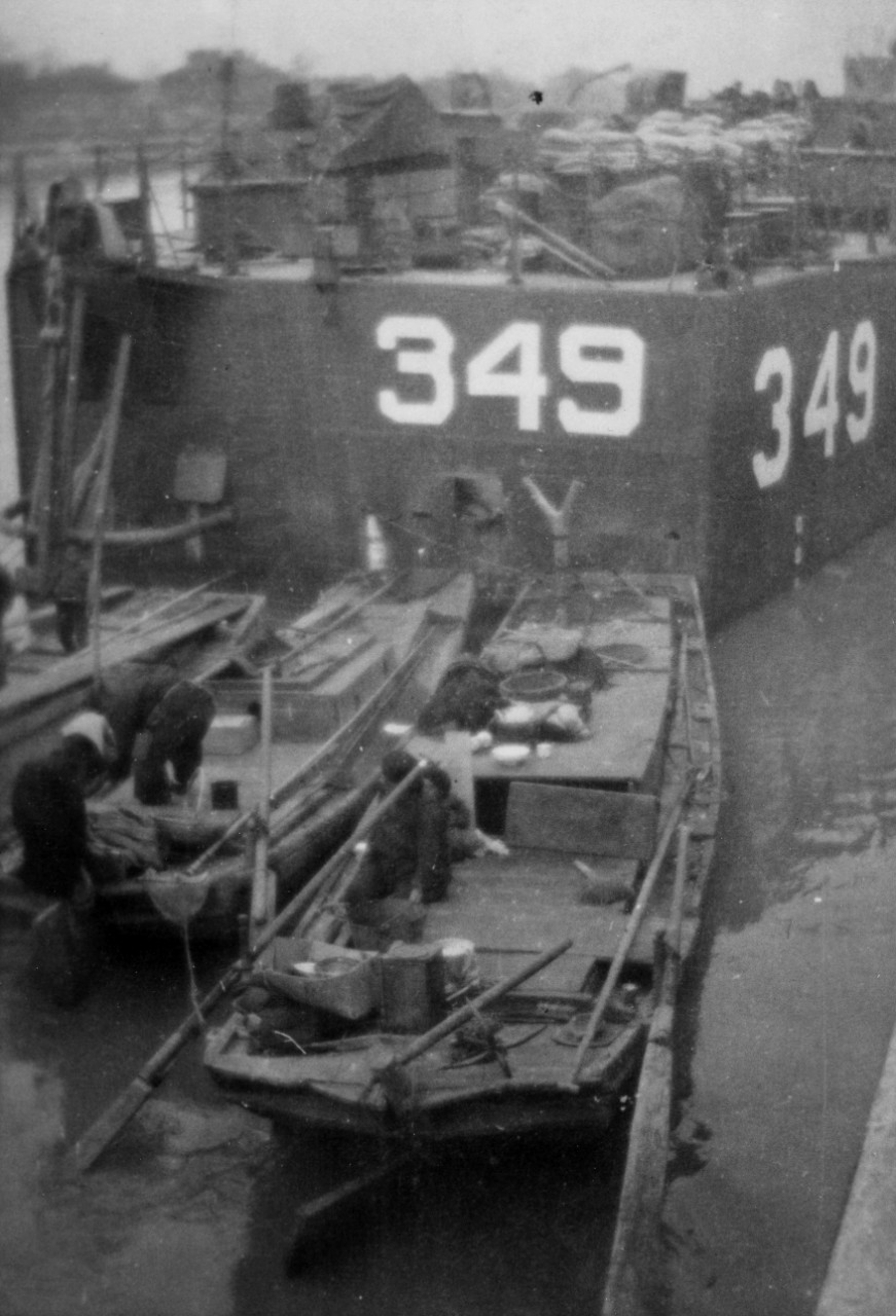 Collection of three photographs (copies) related to the naval service of Edmond J. Hanrahan aboard LSM 349 circa 1945-1946. Subject matter consists of LSM-349 in the Yangtze River, China; Japanese prisoners unloading potatoes in China; and LSM-349’s crew in England, 1946 – Edmond J. Hanrahan is among those in the photograph. 