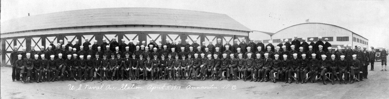 Collection of three oversize panoramic prints related to the naval service of William J. Adams, who served from 1917 to 1919 as an aviation machinist mate. Subjects of the collection consists of company 8 (recruit?) photo from an aviation regiment stationed at Naval Base Norfolk, February 21, 1918; officers and men of Naval Air Station Anacostia, Washington DC, 1918; and the enlisted men of Naval Air Station, Washington DC, 1919. Though not identified, it is assumed that Adams is present in each of the three prints. The three prints are individually identified as S-381-A, S-381-E and S-831-F.