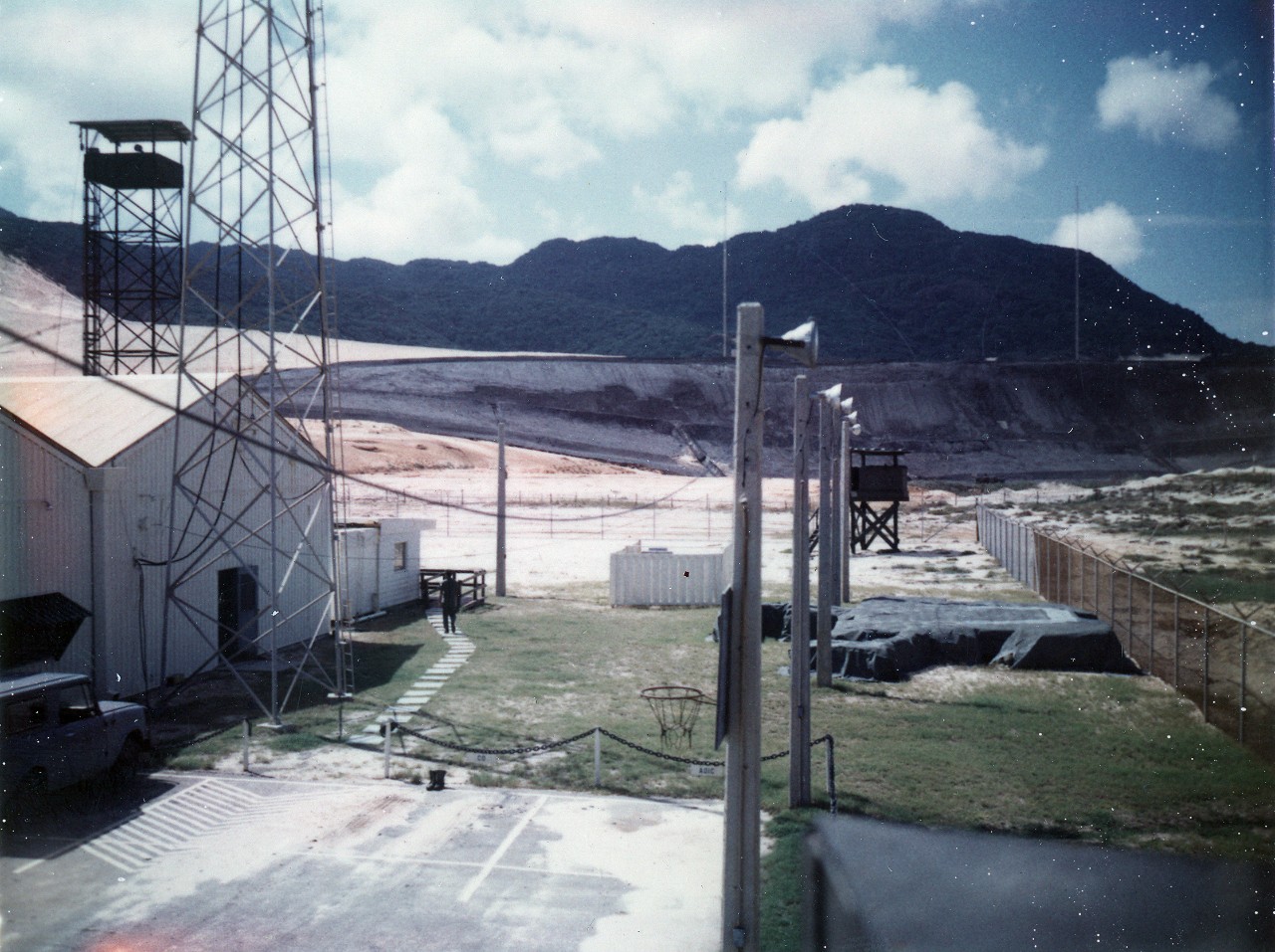 Collection of 14 photos related to Naval Communications Station Cam Ranh Bay, Vietnam, 1970-1971. The donor was commanding officer of NCS Cam Ranh Bay from August 1970 to June 1971. Subject matter consists of general base photos (including aerial), as well some of the many pet dogs at the receiver site, CDR William J. Longhi at his trailer at the NCS receiver site, on patrol in dune buggy, main gate, CO quarters, office briefings. Several of the images have been given individual image numbers in the NH series (NH 106463 – NH 106470). The documents in this collection include base newsletters, change of command announcements, and communication bulletins. 