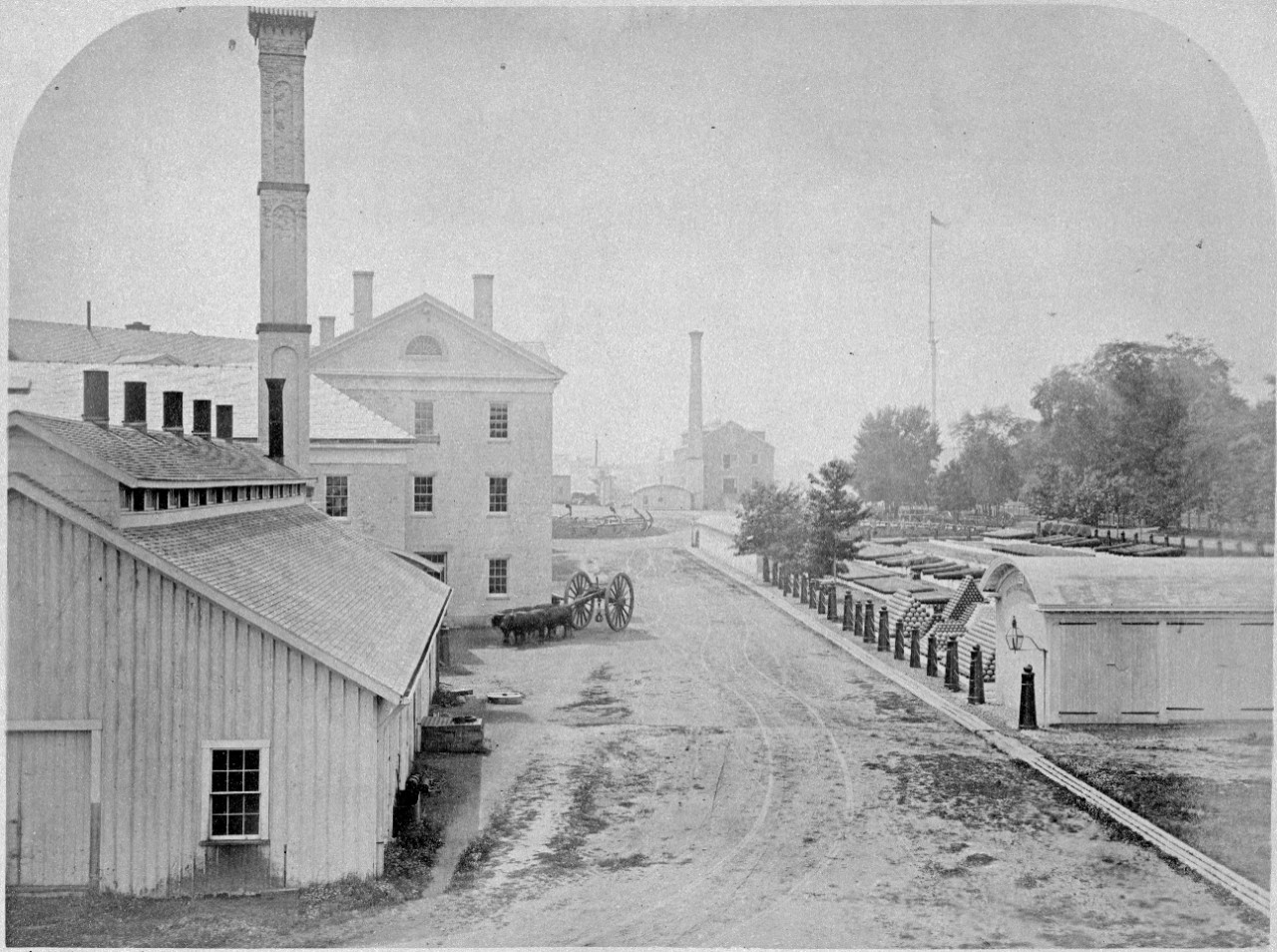 28 photos, mounted on cardboard, showing scenes at the Portsmouth Navy Yard, New Hampshire, circa 1876. Scenes include: floating drydock, offices and buildings, cranes, saluting battery, Marine barracks, park with cannon and stacked shot, bridges, fire engine, docked warships including USS Marion. Most photos have been assigned NH numbers.