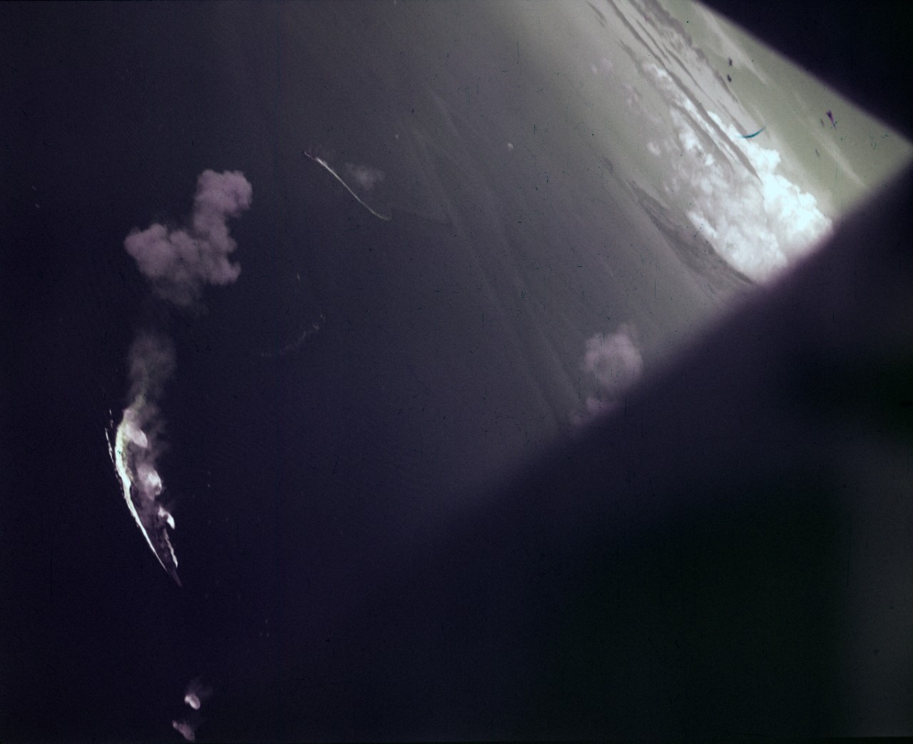Japanese fleet maneuvering while under attack by U.S. Navy aircraft during the Battle of the Sibuyan Sea, 24 October 1944. Ship at bottom center is a Yamato class battleship, with bombs falling nearby. Photographed by Richard Shipman, a photographer from USS Intrepid (CV-11), from the back seat of an SB2C.
