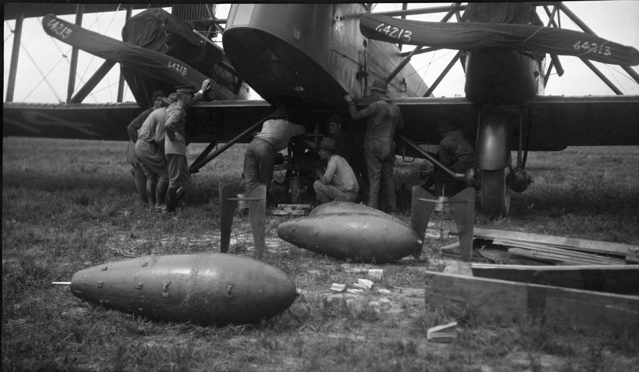 Ground crew loading ordnance on a Martin MB-2 Bomber, circa 1921, likely in support of aerial bombing exercises in conjunction with the Navy. 