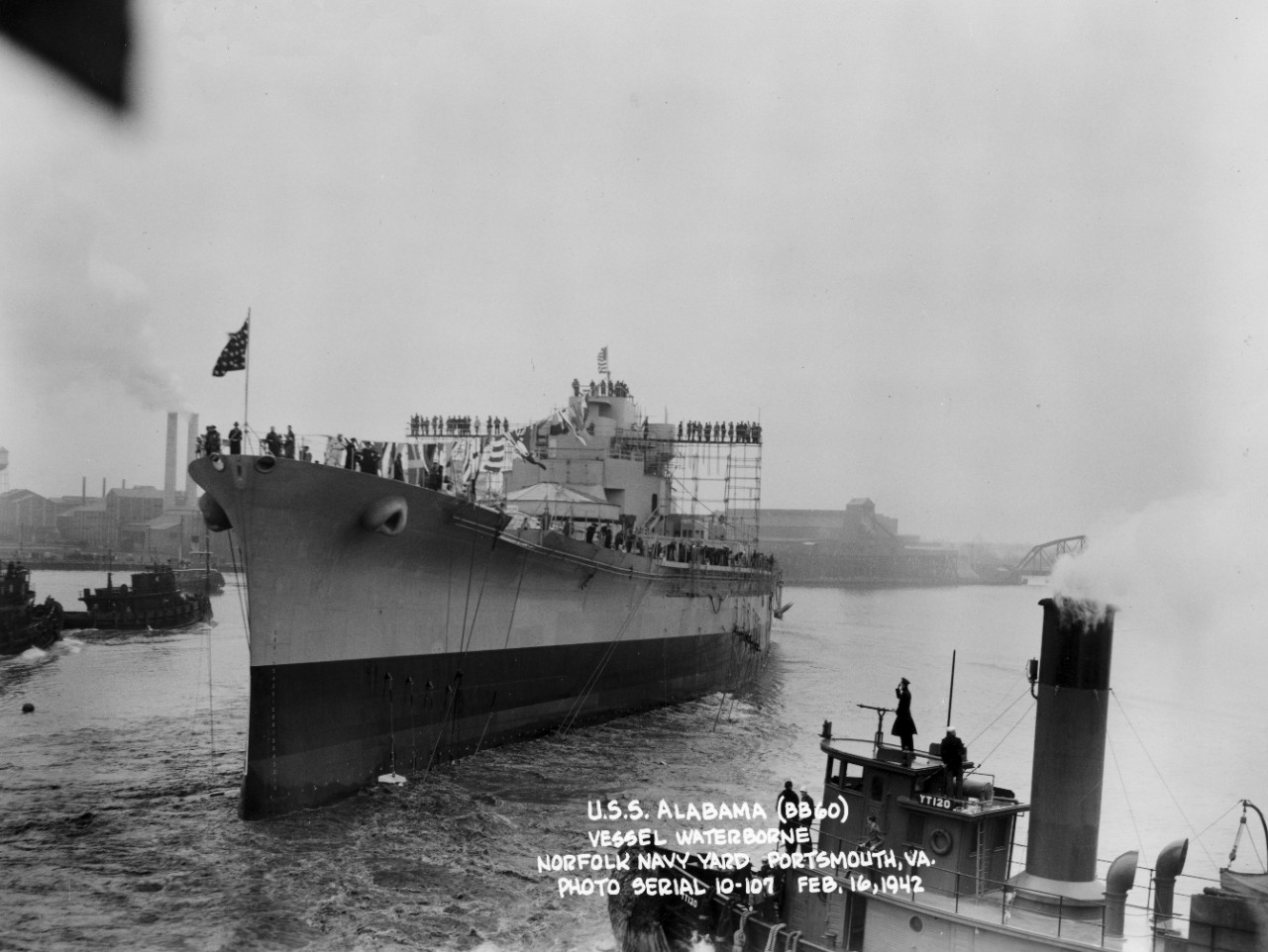 Collection of 24 photographs circa 1942 originally collected by LCDR Carlyle M. Terry, a Public Information Officer at Norfolk Navy Yard, regarding USS Alabama (BB-60) construction and launching activities. Specific imagery consists of launching of the Alabama at Norfolk on February 16, 1942; christening by Mrs. Lister Hill and sponsor’s party – including Secretary of the Navy Frank Knox; the ship sliding down the ways after christening; dinner and concert events; and various images of ship’s launching arrangements and gear (fore poppet, after poppet, chain drags, cable attachments, starting jacks, etc.). 