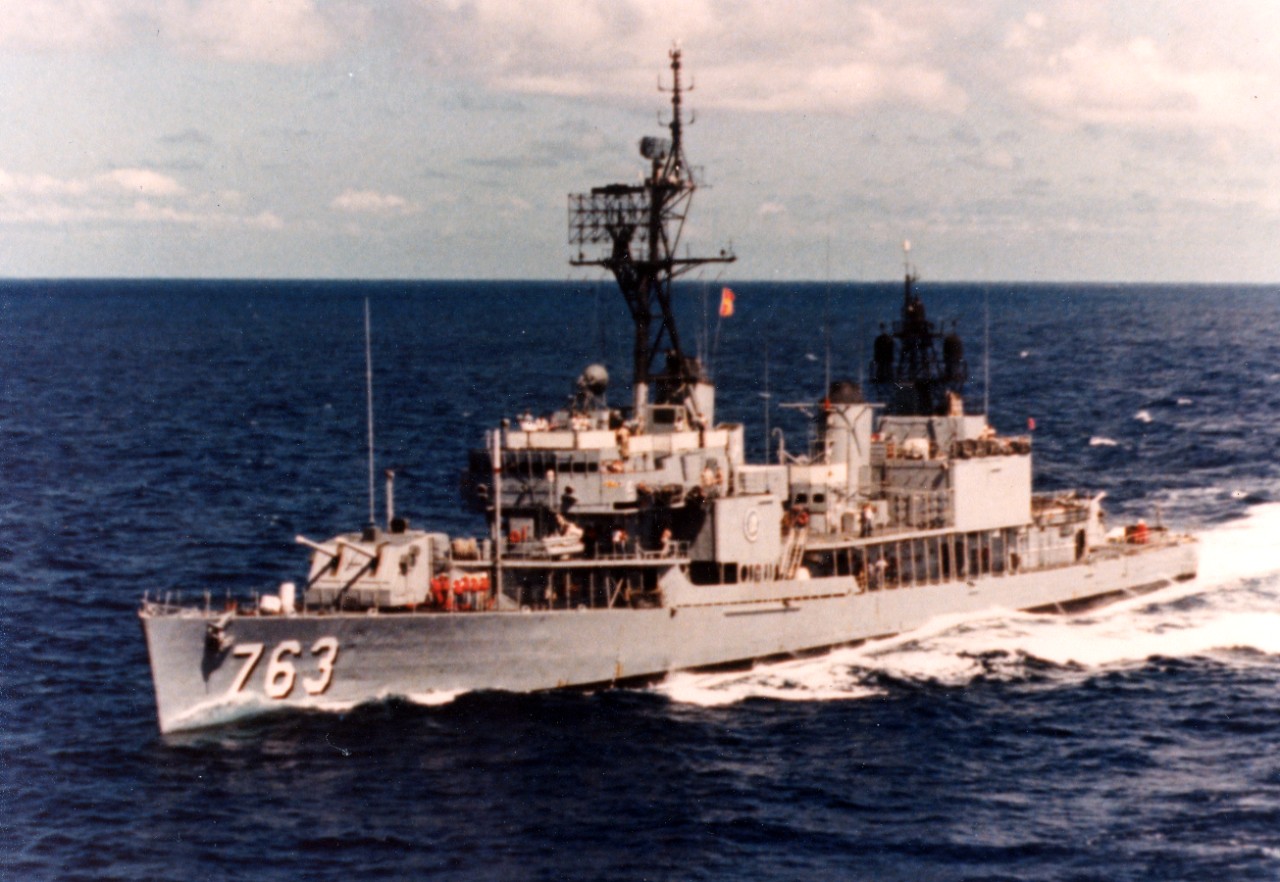 Collection of 50 photographs and negatives, circa 1983, transferred from the ship upon decommissioning. The subject matter consists of the ship underway at sea; crewmembers performing various tasks aboard ship (line handling, electronics repair, brazing pipe, testing boiled feed water, cabinet work, etc.); reenlistment ceremony with SECNAV John Lehman officiating; change of command ceremony; recreational activities; burial at sea ceremony; berthing spaces; and general views of the crew relaxing aboard ship. Also included are five photographs of officers: CAPT Allen (C/O of the ship?), LCDR Cooper (ship’s X/O), and CDR Paul V. Murphy. 