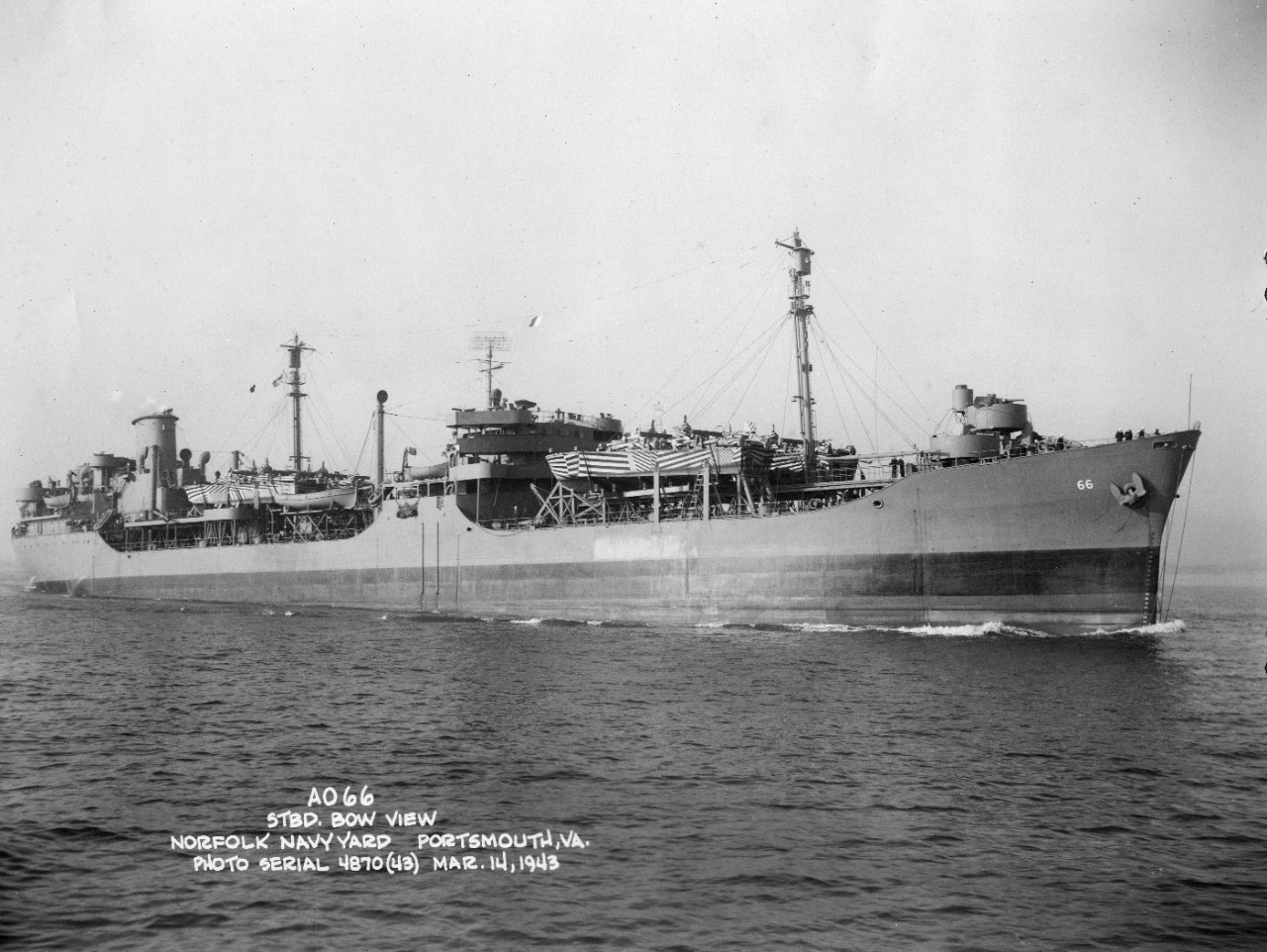 Starboard quarter view of USS Atascosa (AO-66) underway in light load condition with camouflaged PT boats as deck cargo fore and aft off the Norfolk Navy Yard, Portsmouth, VA, on 14 March 1943. She was the former S.S. Esso Columbia.