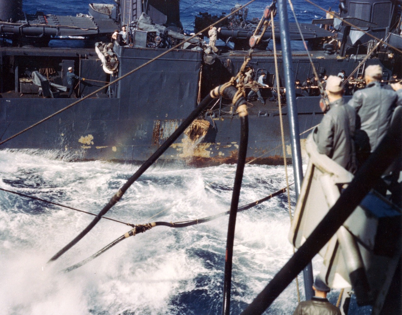 USS Halsey Powell (DD-686) prepares to refuel from USS Wisconsin (BB-64) during operations near Japan, 27 February 1945. Note line-handling party hauling in, and chipped paint near the waterline.
