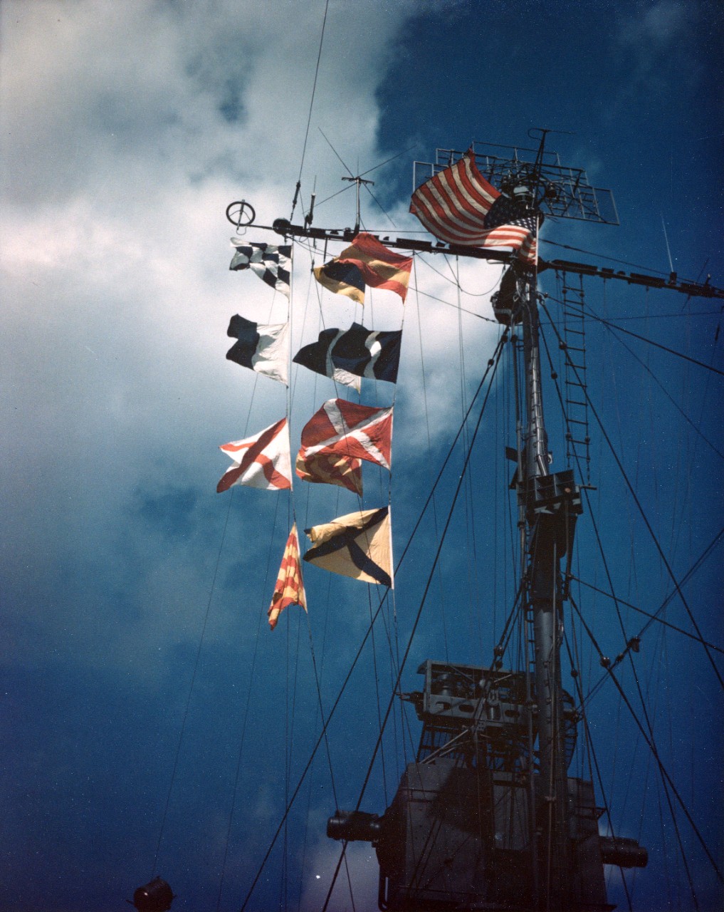 "Navy Day, 1945" spelled out in signal flags, flying from the mast of a destroyer at the Charleston Navy Yard, South Carolina, circa 27 October 1945. Note Mk. 37 director at bottom and SC-2 type radar antenna atop mast, along with other antennae. 