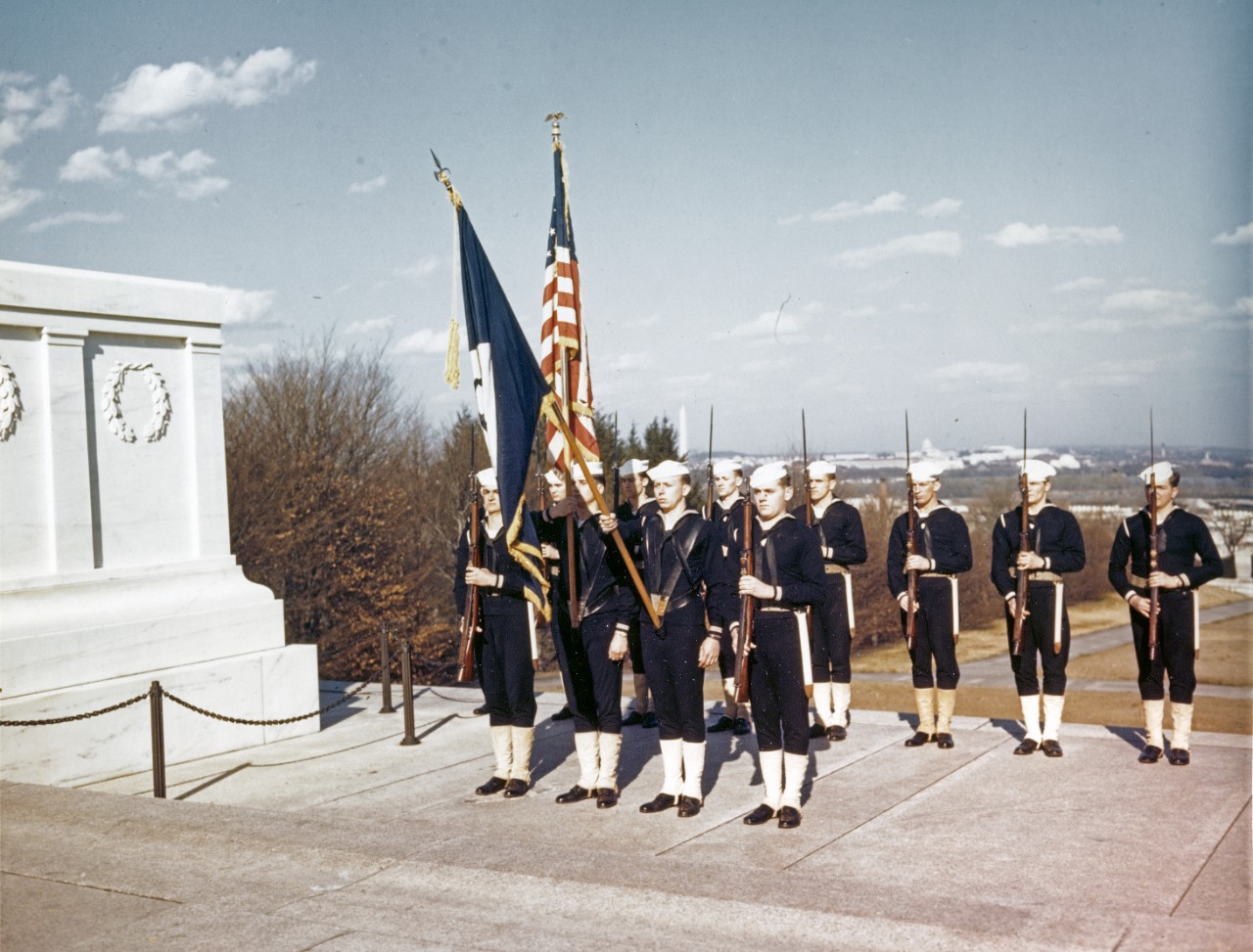 Navy Honor Guard stands at "present arms" beside the Tomb of the Unknown Soldier, during World War II. Washington, D.C. can be seen in the distance, with the Washington Monument in the center and the Capitol farther to the right. Photographed prior to April 1944.