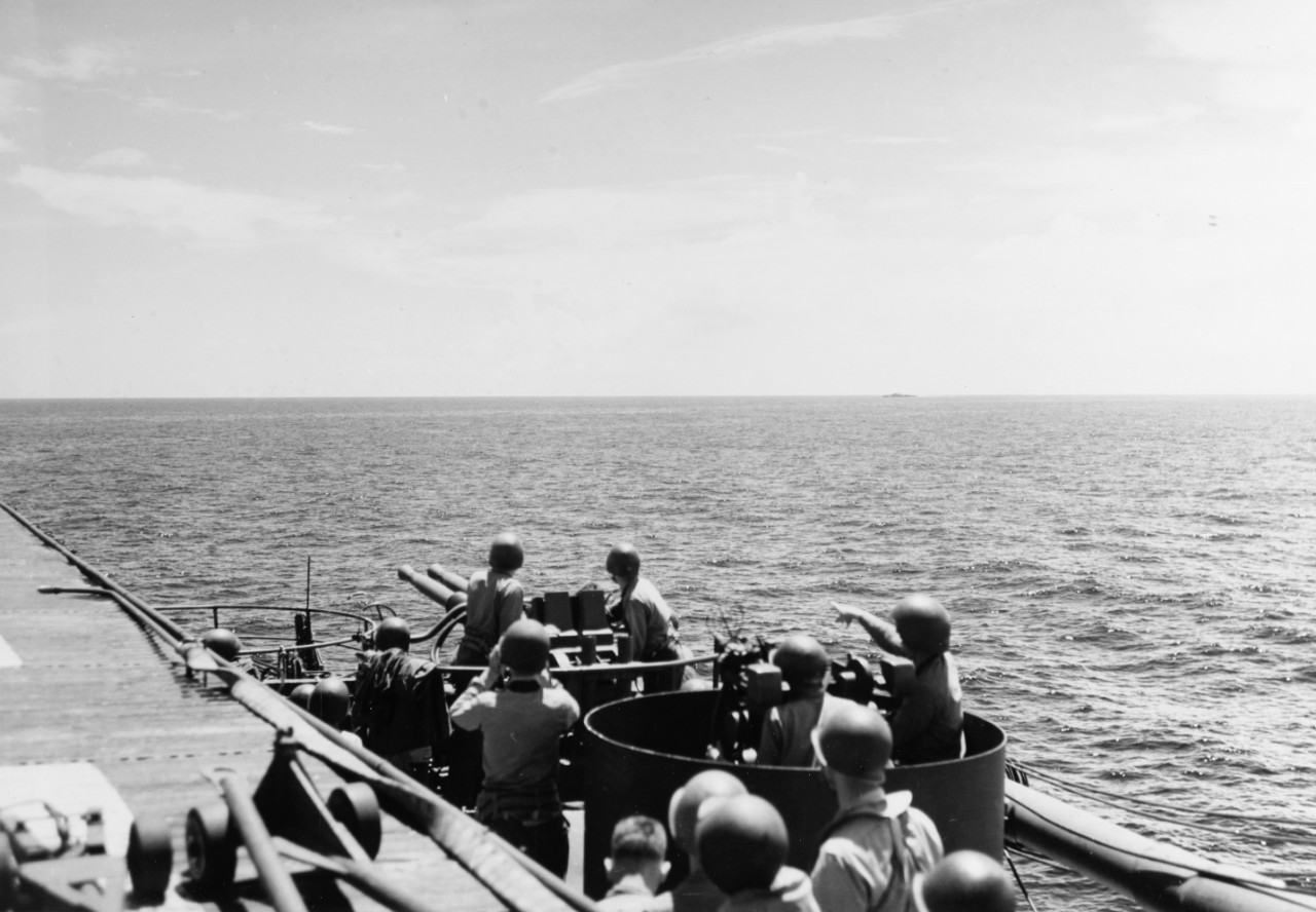 40mm guns of USS Sangamon (CVE-26) on alert on 26 October 1944. Bursts on the horizon remain from an attack a few minutes earlier.