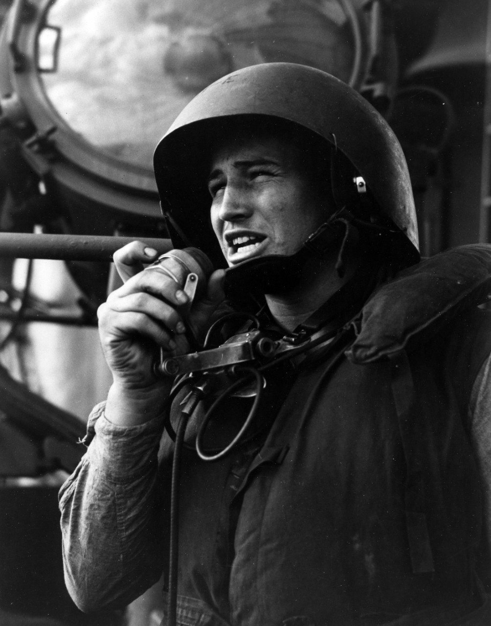 "Talker" on board the carrier relays gunner officer's orders to gun crews, during training operations in the Pacific, August 1943.