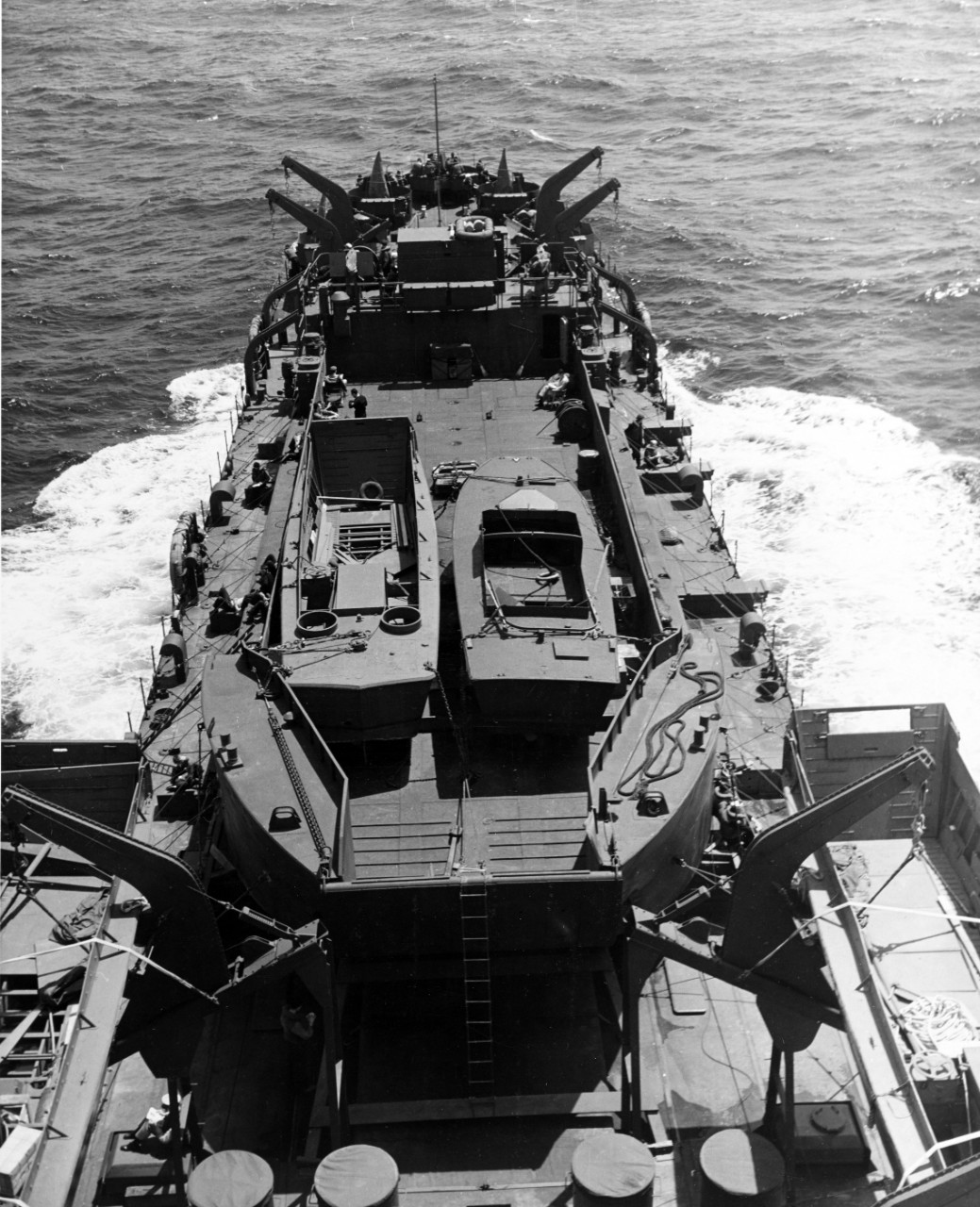 LST-350 en route to North Africa, in company with other LSTs, 15 April 1943. She is carrying as deck cargo an LCT, which is in turn carrying an LCPR and a small patrol boat.