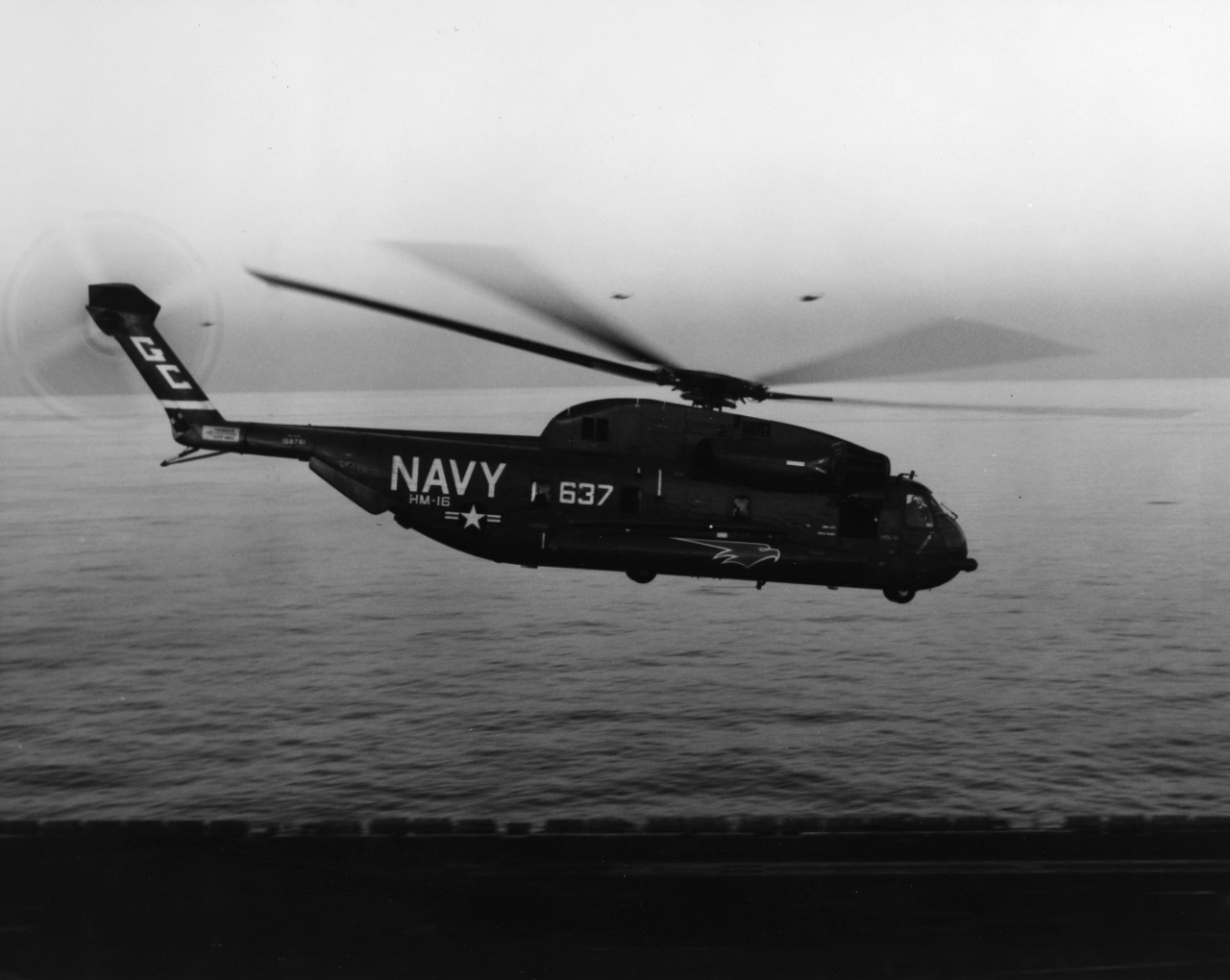 Right side view of an RH-53D Sea Stallion helicopter in flight just above the flight deck of USS Nimitz (CVN-68) in the Indian Ocean.