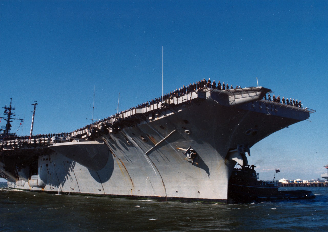 Naval Station, Norfolk, VA - crewmen man the rails aboard the aircraft carrier USS America (CV-66) as the ship, returning to its home port after an extended deployment, is maneuvered to the pier. November 10, 1989. 