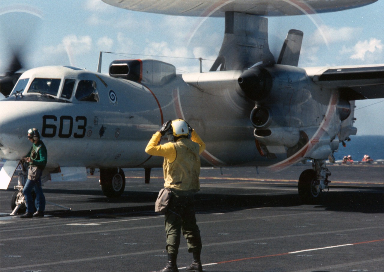 Flight deck crewmen make final preparations to launch an E-2C Hawkeye aircraft from the nuclear powered aircraft carrier USS Theodore Roosevelt (CVN-71). The aircraft belongs to Carrier Airborne Early Warning Squadron 123 (VAW-123), part of Carrier Air Wing 1 (CVW-1), which is assigned to the aircraft carrier USS America (CV-66).