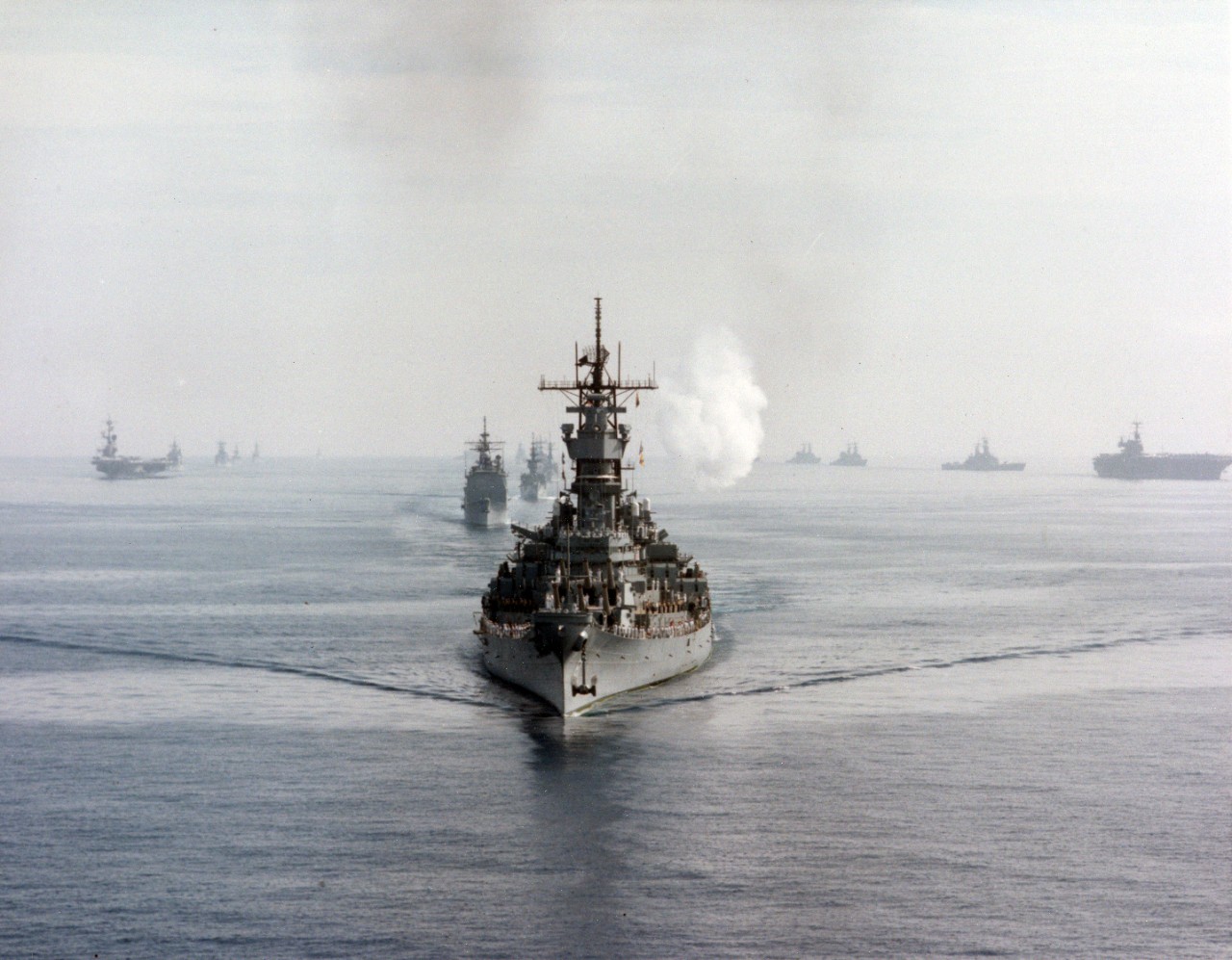 The battleship USS Iowa (BB-61) leads its battle group into Augusta Bay, Sicily. The aircraft carrier USS Coral Sea (CV-43) and its battle group are at left; the aircraft carrier USS Saratoga (CV-60) and its battle group are at right.