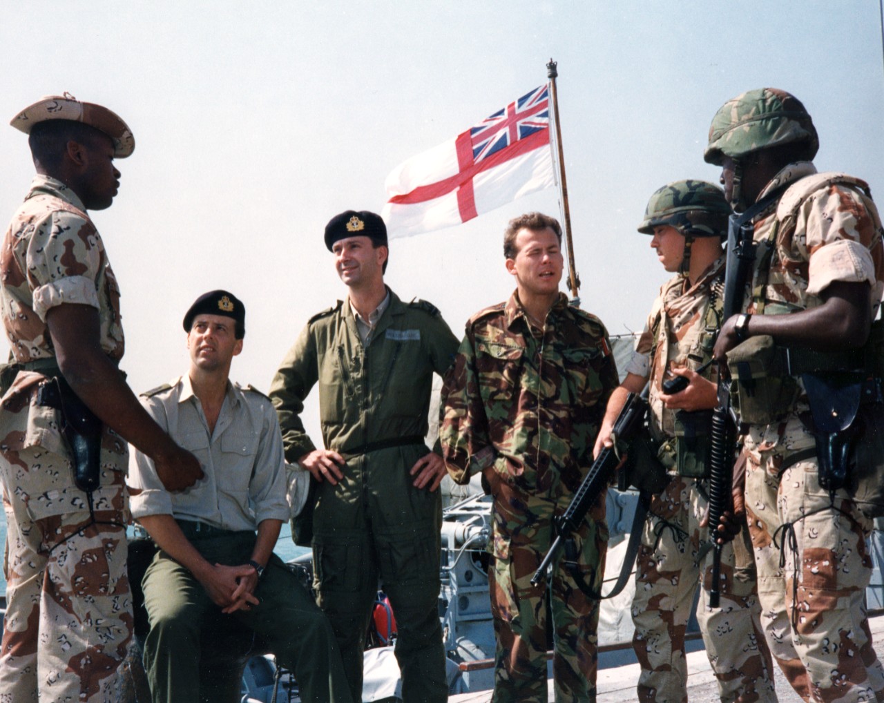 US and British military personnel converse in Bahrain on a pier beside the Royal Navy's logistic landing ship RFA Sir Galahad (L-3005). Pictured, from left, are: Corporal Lemuel Maynor, USMC; Lieutenant Paul Dobson, Lieutenant D.P. Wolstenholme, and Diver Steven Fitzjohn of the&nbsp;Royal Navy; Lance Corporal Riant L. Polson and Lance Corporal Reginald Robinson, USMC. Polson and Robinson are armed with M-16A2 rifles. The British and US military personnel are making a port call during Operation Desert Storm.