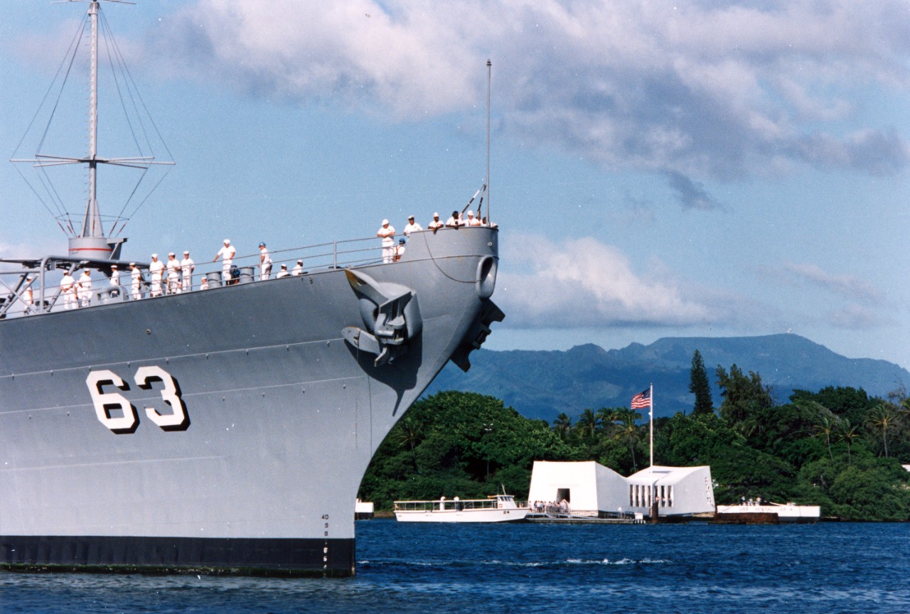 USS Missouri (BB-63) arrives at Naval Station Pearl Harbor on Survivor's Day, when the sailors and Marines of the battleships that were sunk or damaged in the 7 December 1941 attack on Pearl Harbor are honored. In the background is the USS Arizona Memorial.