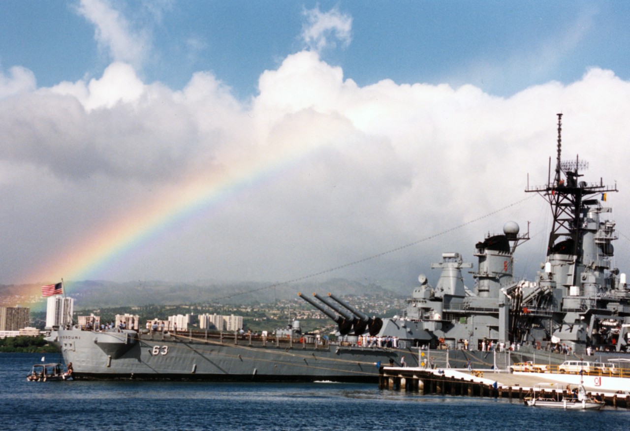 A rainbow highlights the sky in the background as the battleship USS Missouri (BB-63) lies tied up at Naval Station Pearl Harbor, Hawaii. Missouri is in Hawaii to take part in the observance of the 50th anniversary of the Japanese attack on Pearl Harbor.
