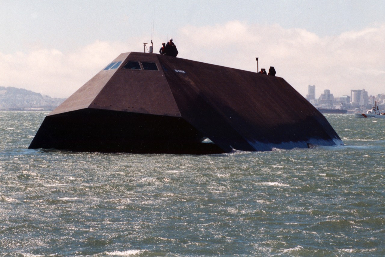 Experimental stealth vessel Sea Shadow (IX-529) underway in San Francisco Bay. Note the city skyline in the background, as well as a Coast Guard vessel.