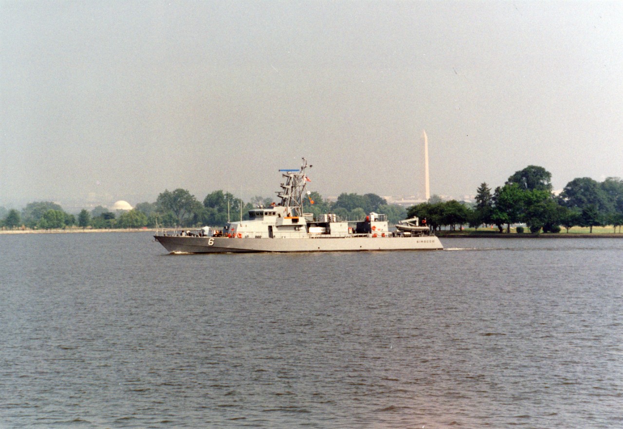 Port side view of the coastal patrol boat USS Sirocco (PC-6) steaming down stream after departing the Washington Navy Yard. The Jefferson and Washington Memorials are almost lost in the haze caused by the heat and 97% humidty.