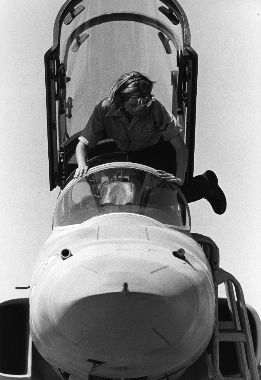 Petty Officer 3rd Class Roberts climbs into the cockpit to service an F-5E Tiger II adversary aircraft assigned to the Navy Fighter Weapons School at NAS Miramar, California. Known as "Top Gun," the school provides air combat maneuvering (ACM) training for Navy and Marine Corps pilots.