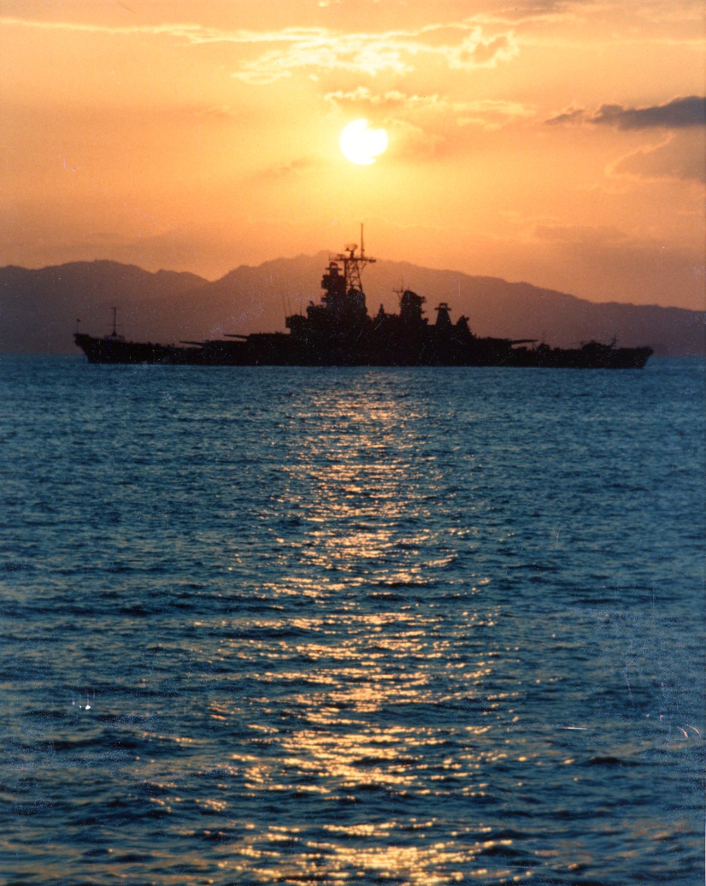 A port side view of the battleship USS Iowa (BB-61) at sunset, moored off Puerto Caldera, Costa Rica.