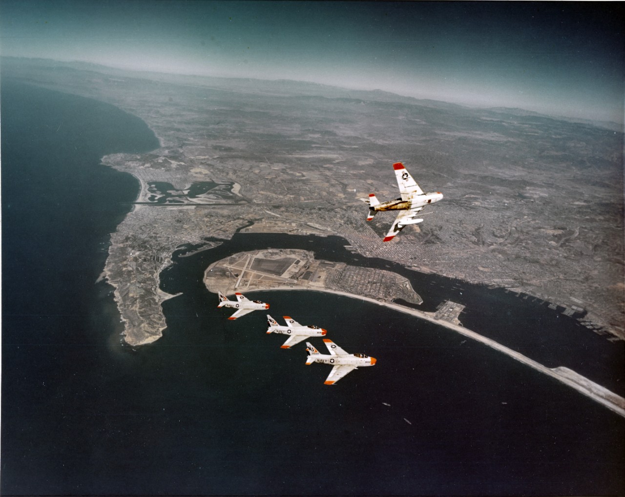 A formation of FJ-4 Furies from Fighter Squadron 121 (VF-121) in flight over San Diego, California.